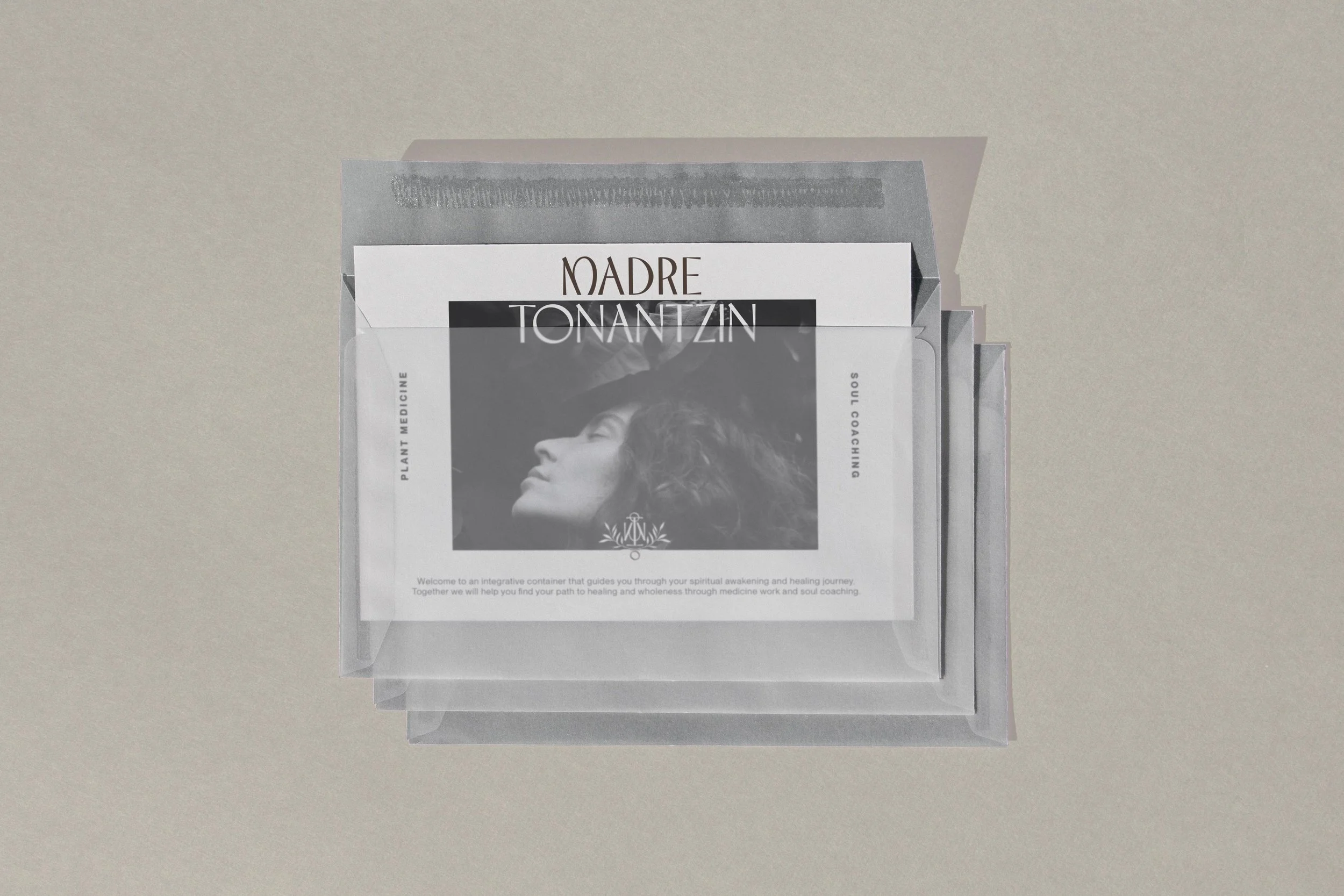 A stack of informational pamphlets or brochures inside a transparent plastic folder on a beige surface. The brochure features black-and-white imagery and text about Soul Coaching and plant medicine.