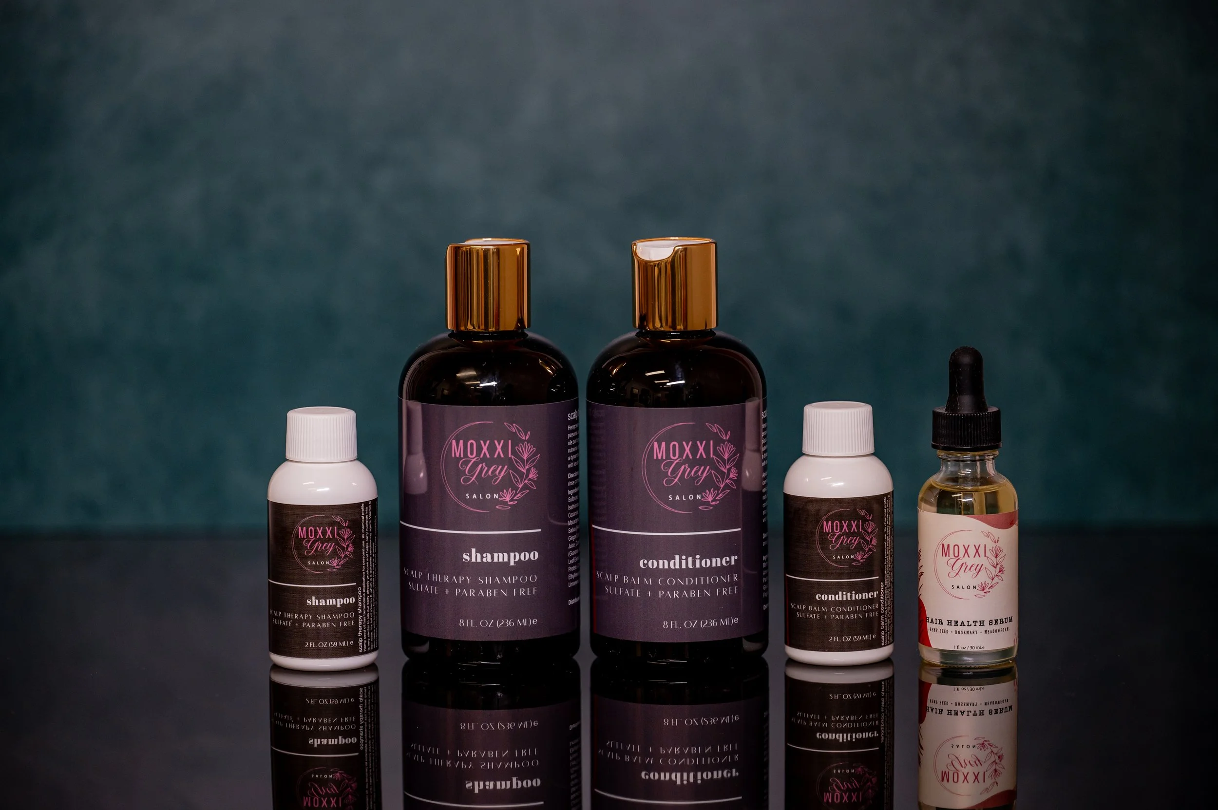 Collection of hair care products including shampoo, conditioner, and hair health serum sold at Moxxi Grey Salon in Colleyville, TX, The best hairdresser in DFW, Dallas, Fort Worth, and Mid-Cities