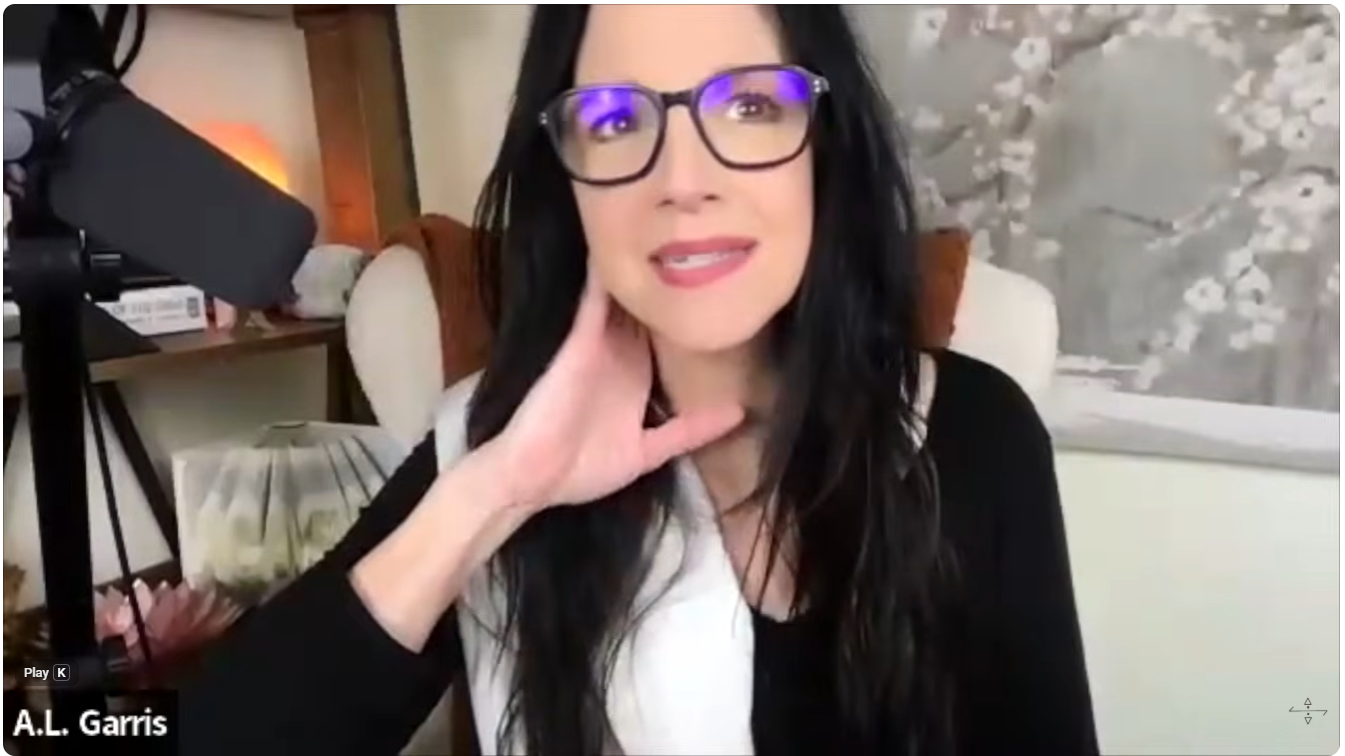 A.L. Garris speaking during an Acasma Planet of Light and Healing Grid livestream, seated in front of crystals and spiritual tools.
