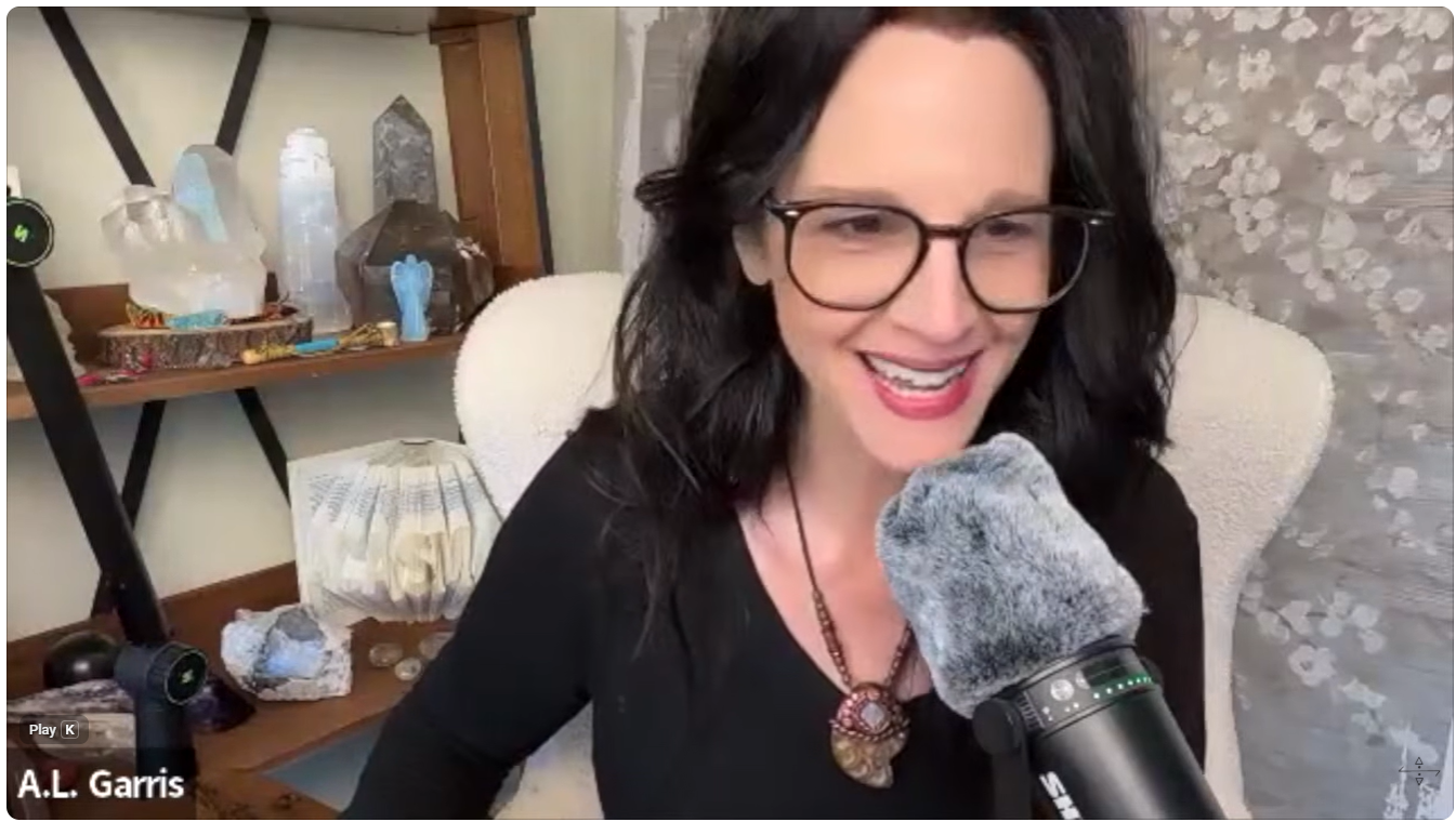 A.L. Garris speaking during an Acasma Planet of Light and Healing Grid livestream, seated in front of crystals and spiritual tools.