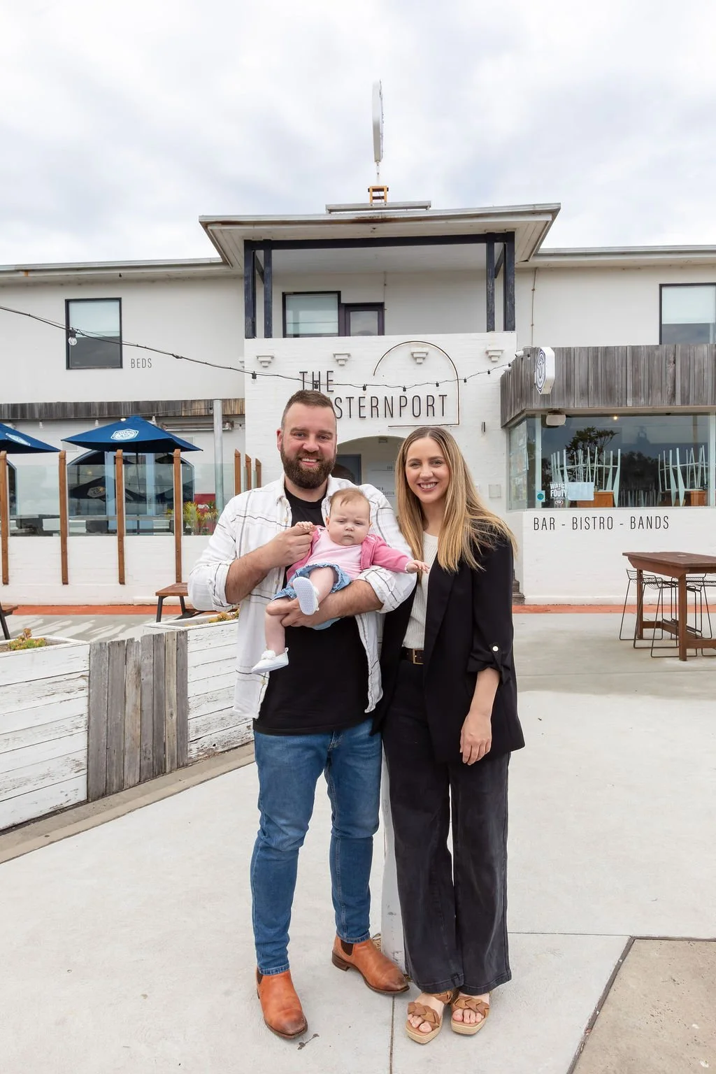 Image of the owners - Morgan, Shiree and their 3 month old baby Lily at the front of the Westernport Hotel, San Remo