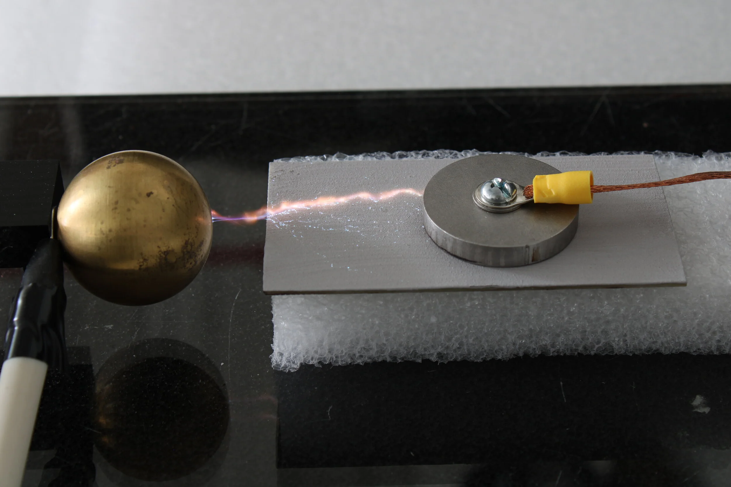 High-voltage lab test showing surface flashover from electrode to ALP20-coated receptor.
