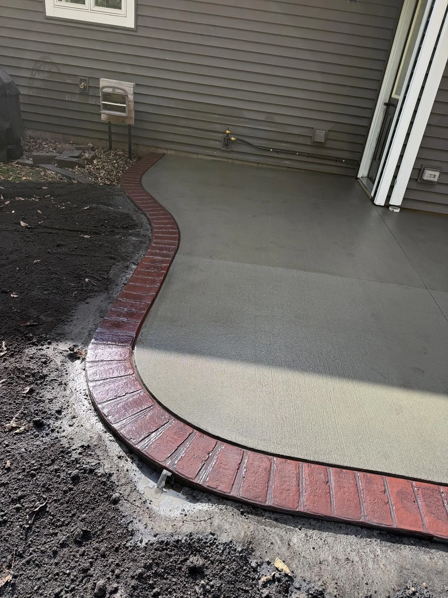 Brick stamped border on a driveway extension using @decocrete_supply brick red color hardener with black release.