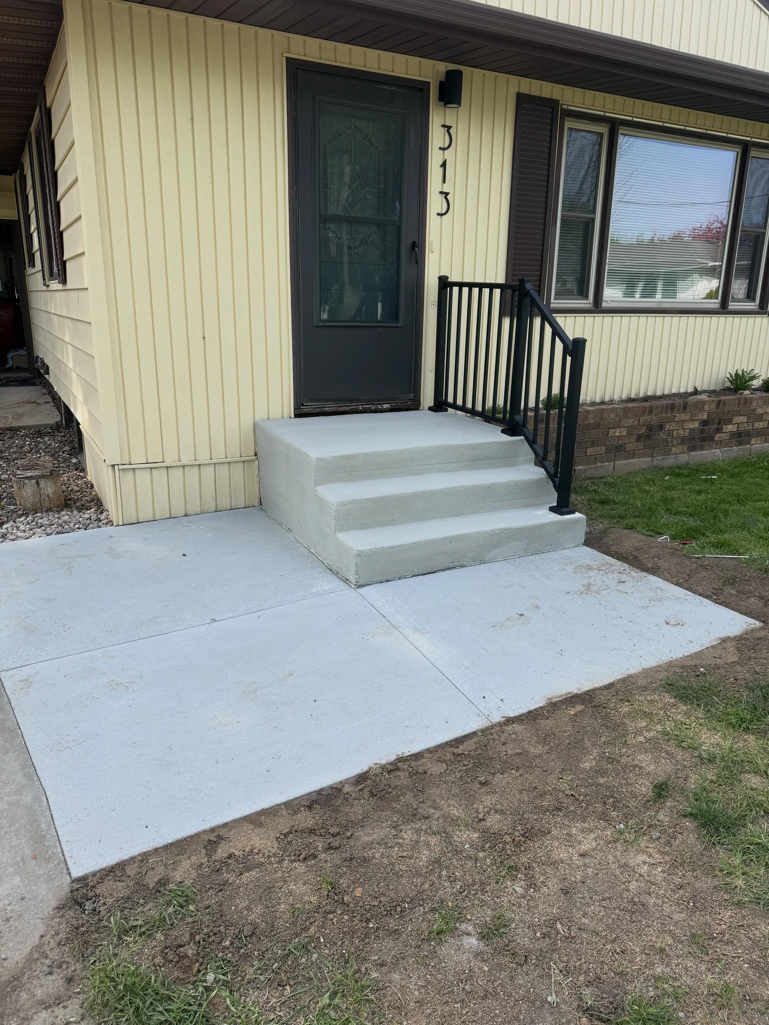 Poured a new walkway, resurfaced the step, and put a new handrail up.