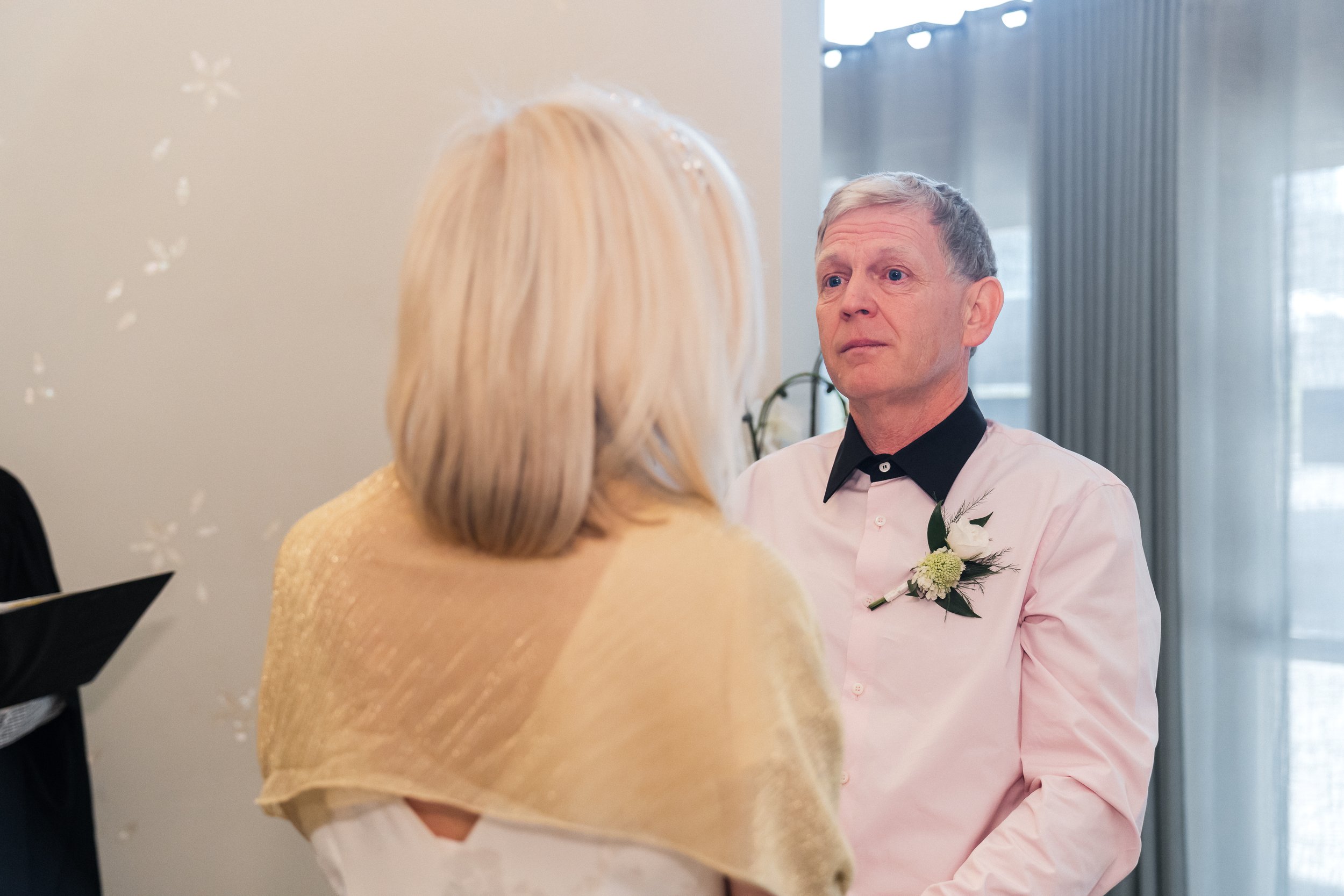 “Older couple smiling during official vows inside Toronto City Hall