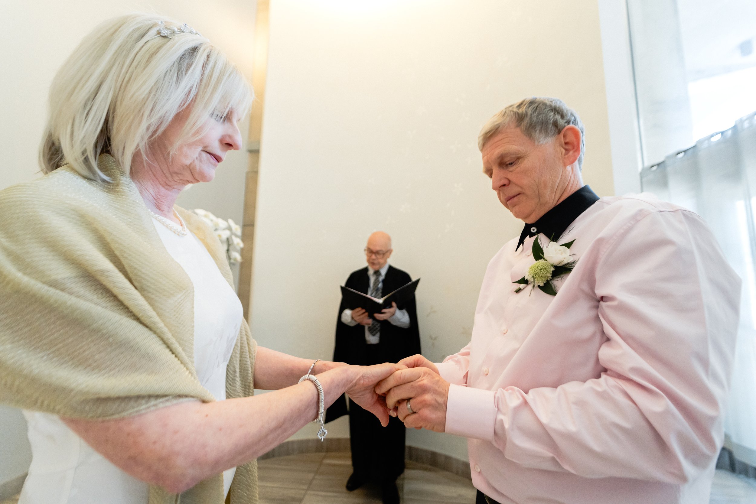 Bride and groom exchanging rings at Toronto City Hall council wedding chamber