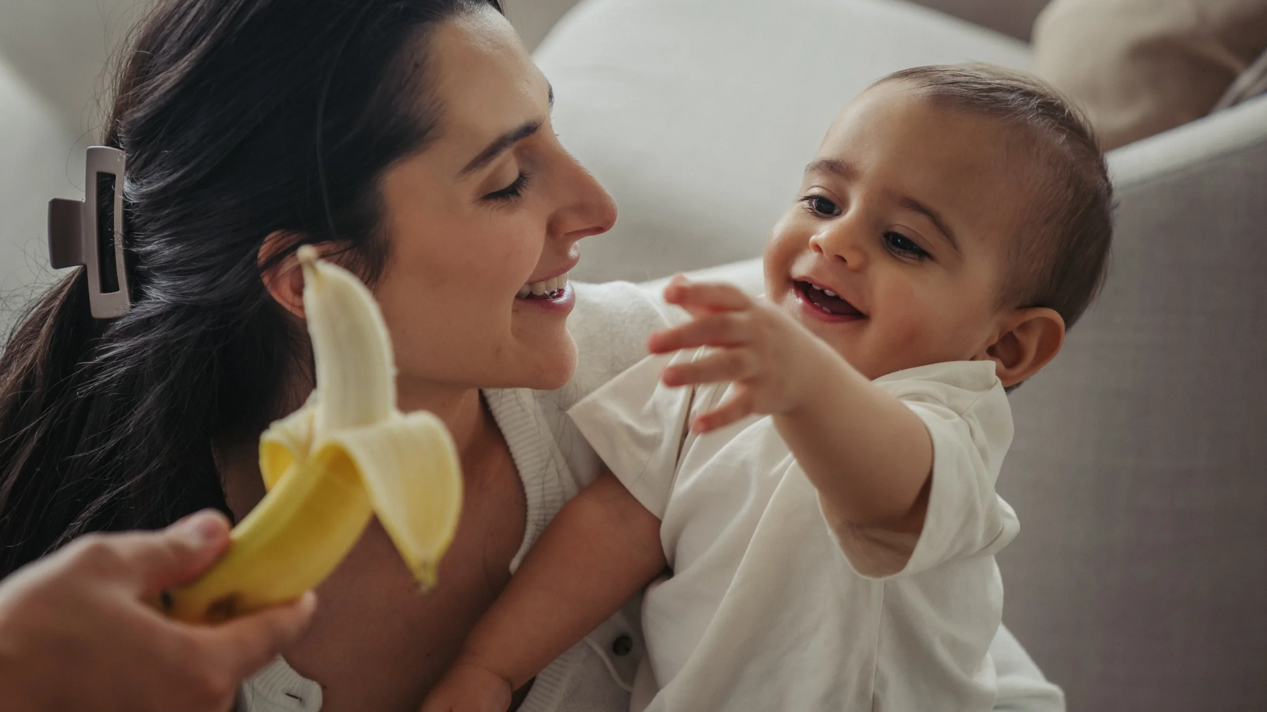 in-home-family-photography-toronto-baby-reaching-for-banana.jpg