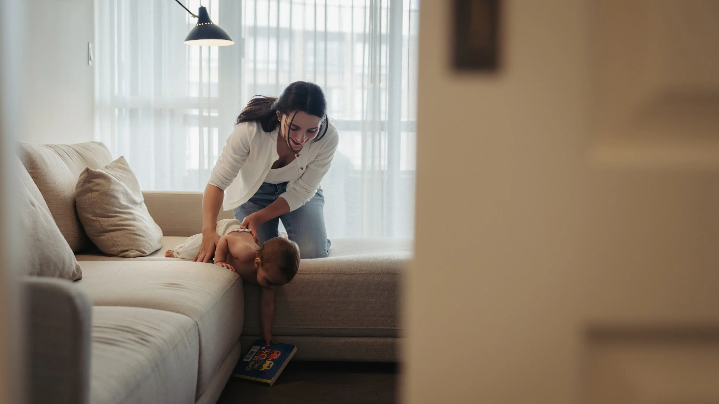 at-home-baby-photos-toronto-mom-and-baby-reaching-for-book.jpg