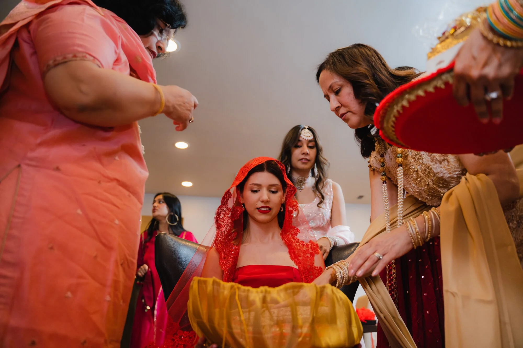 henna-night-toronto-elders-placing-henna-red-veil.jpg