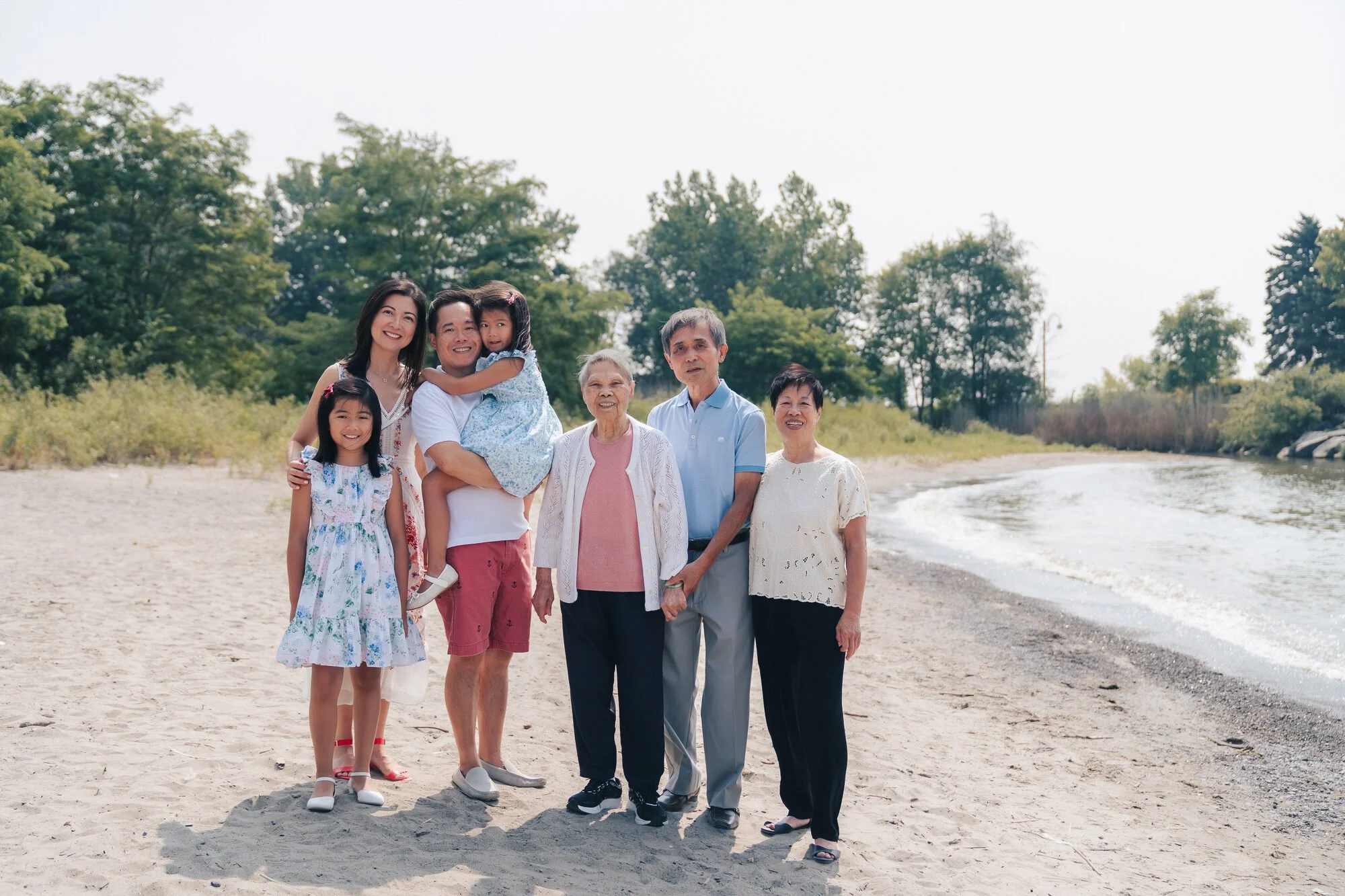 family-photographer-toronto-mother-hugging-daughters-beach.jpg