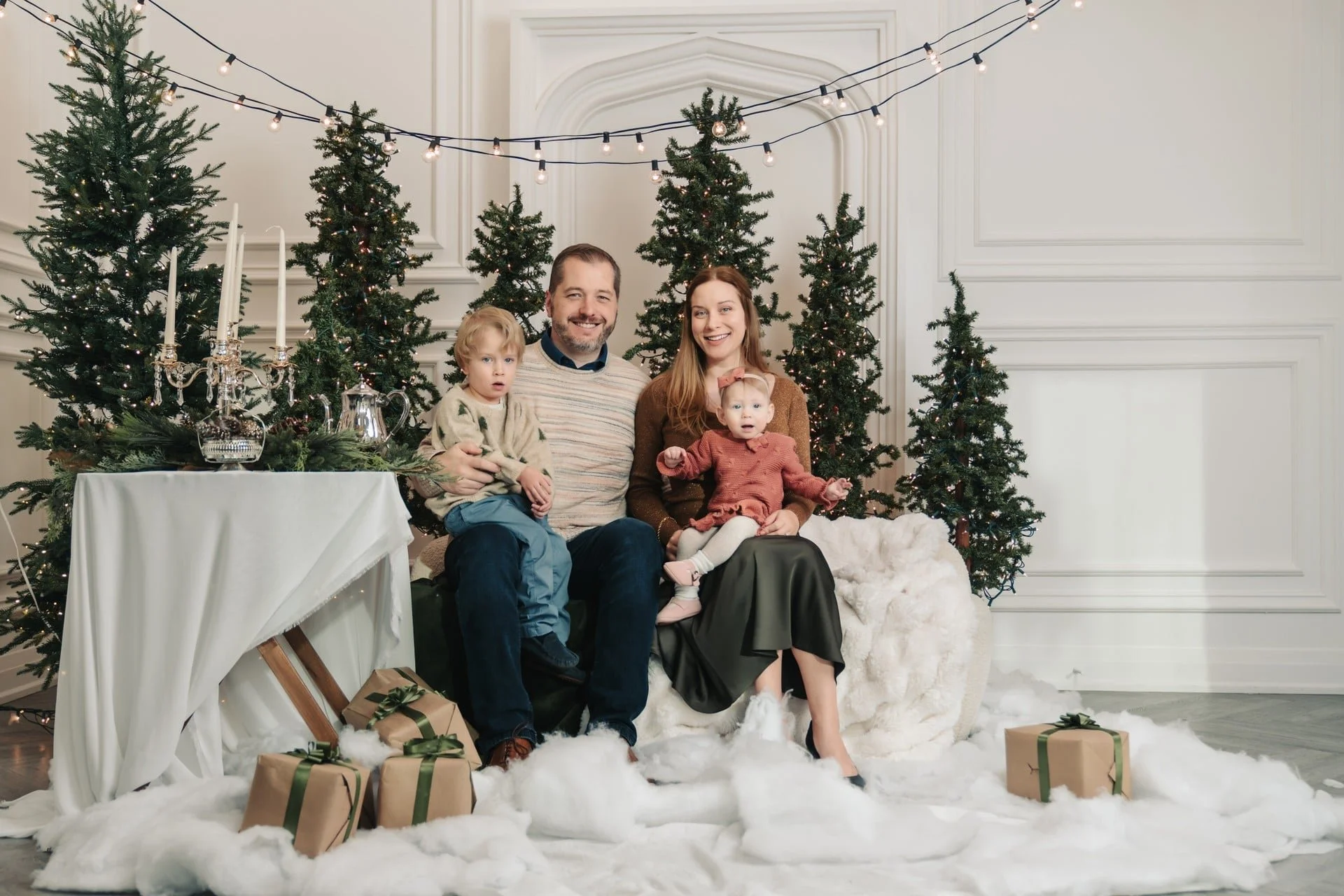 Family Christmas photoshoot with fairy lights and evergreens, Toronto studio