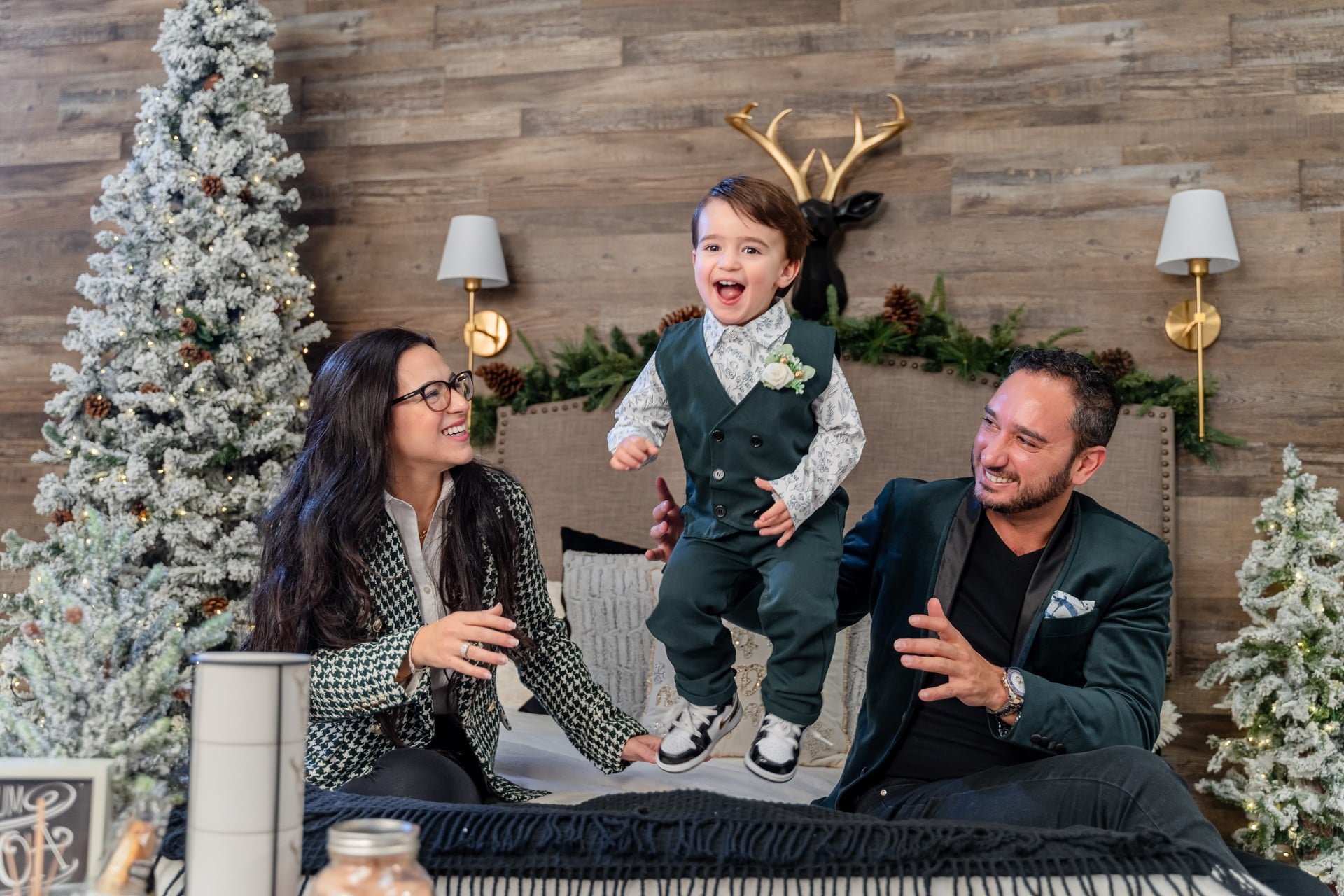 Boy in reindeer antlers with his parents at a Toronto Christmas photoshoot