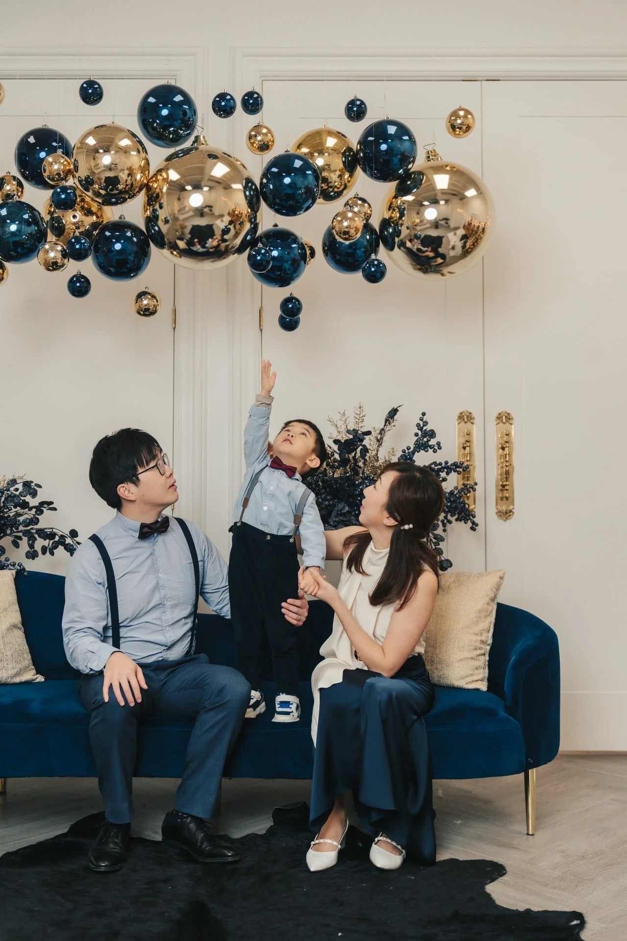 Family on a blue sofa at a navy-and-gold Christmas photoshoot, Toronto