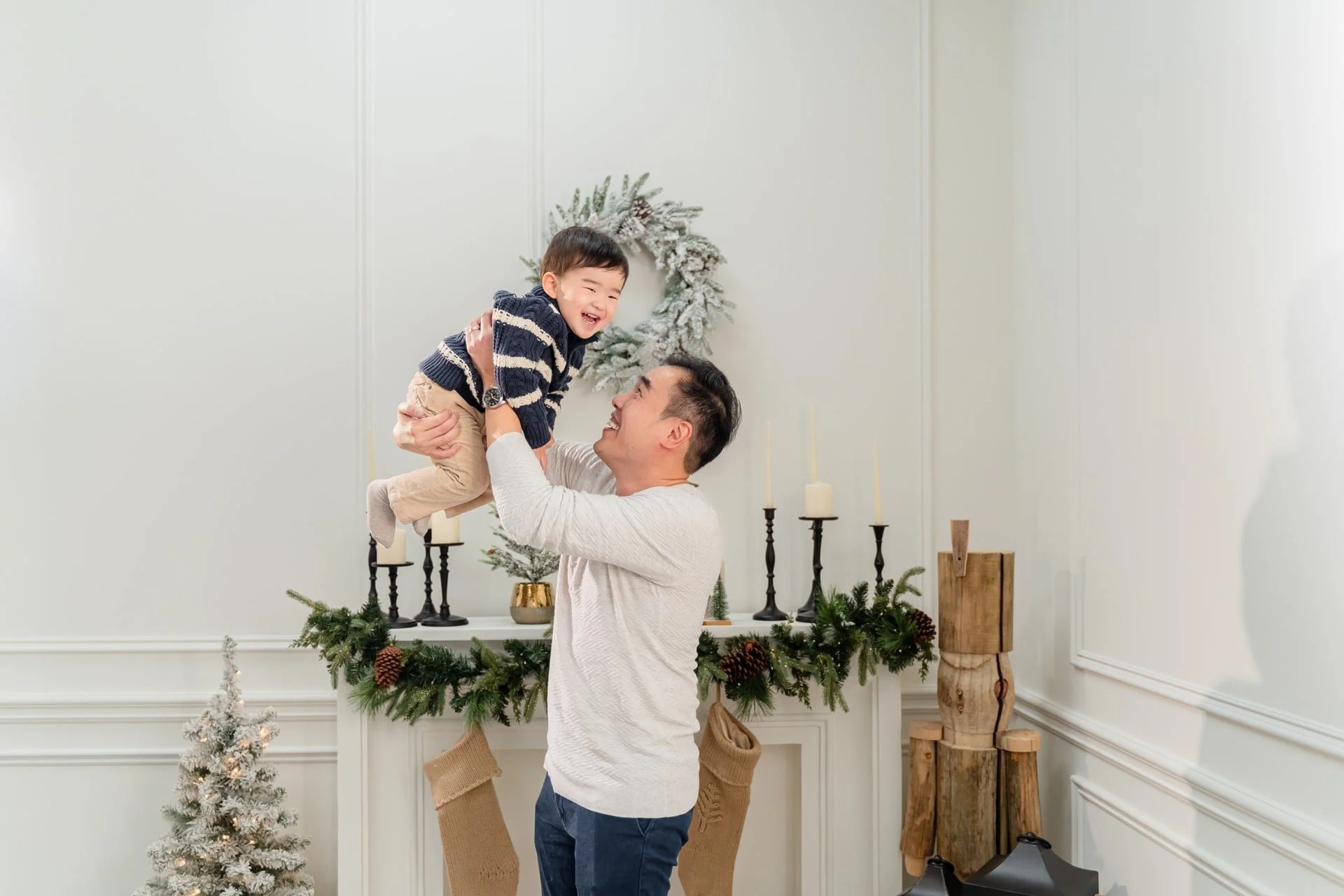 Dad lifting his toddler at a Christmas photoshoot, Toronto studio