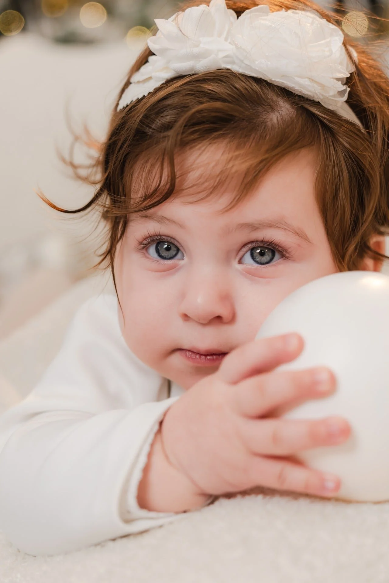 Baby girl in a white bow at her first Christmas mini session, Toronto