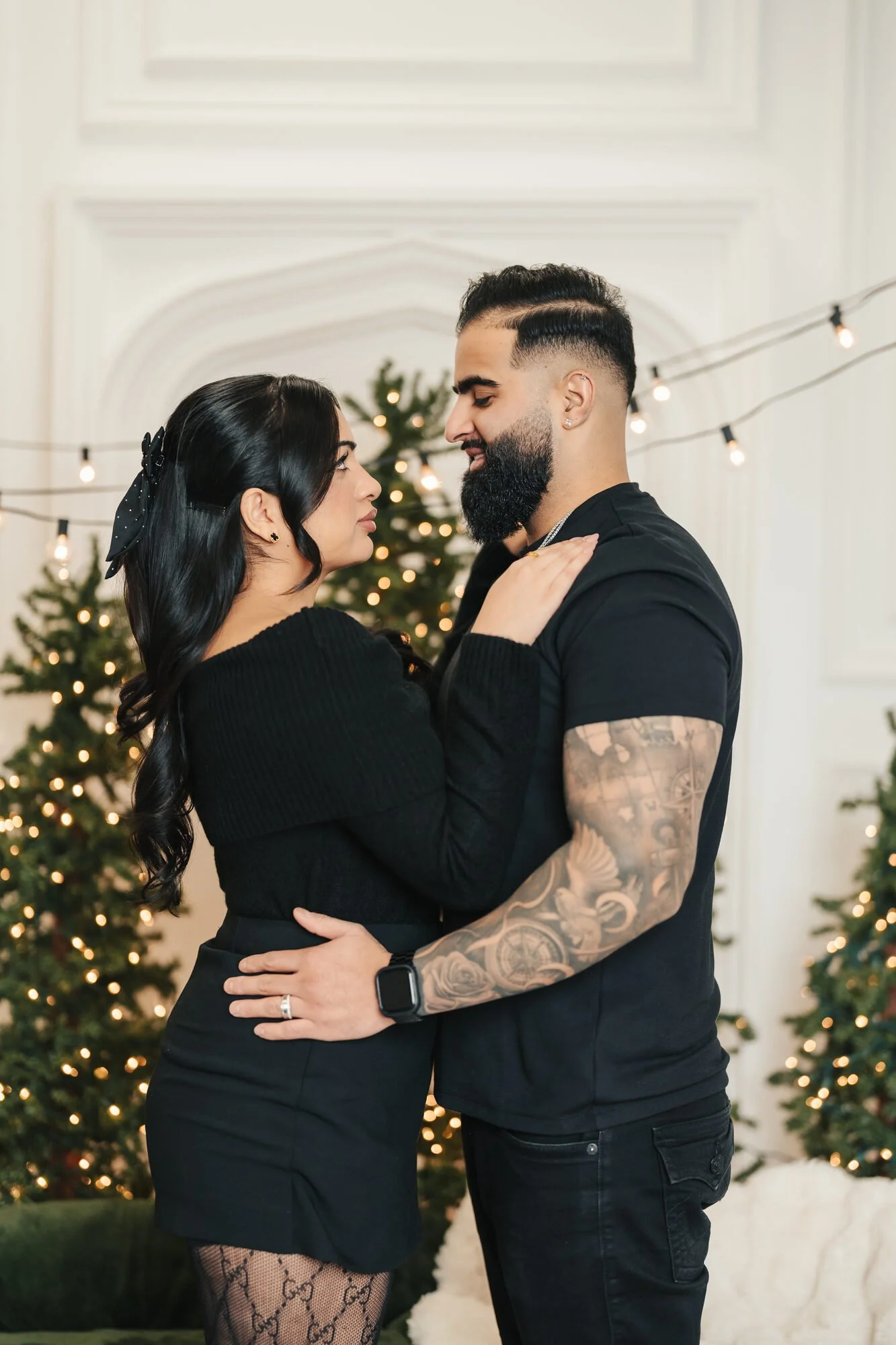 Couple by the Christmas tree at a cozy couples photoshoot in Toronto
