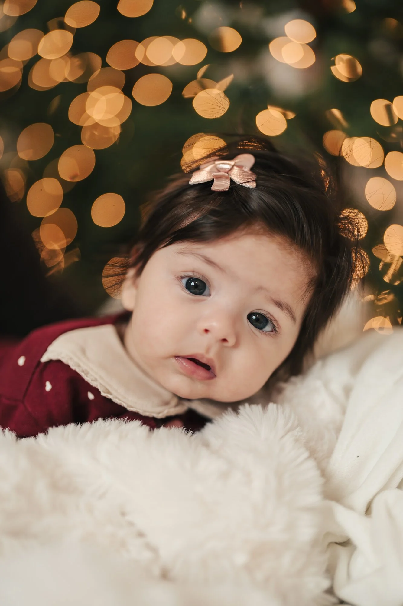 Baby in the Christmas lights at a first-Christmas photoshoot in Toronto