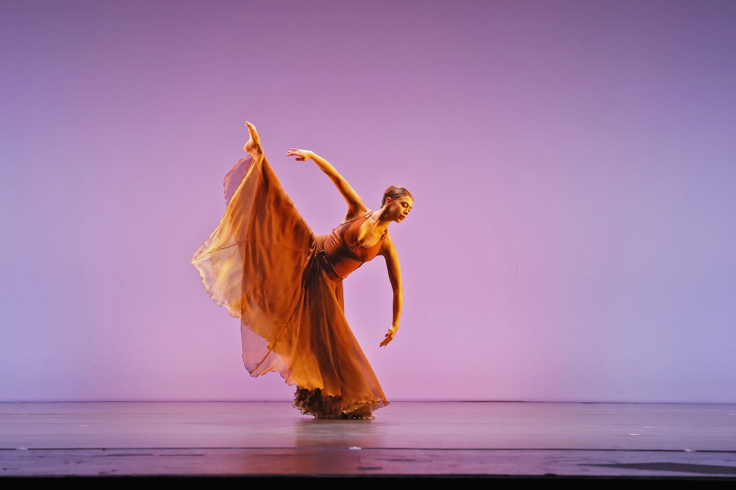 Female dancer with a brown dress on in a tilt
