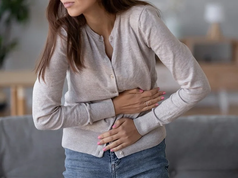 A woman clutching her stomach in pain