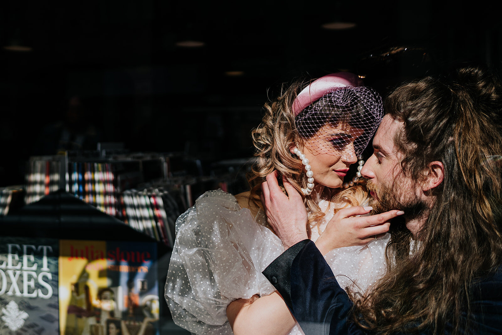 a bride and groom kissing in a record shop