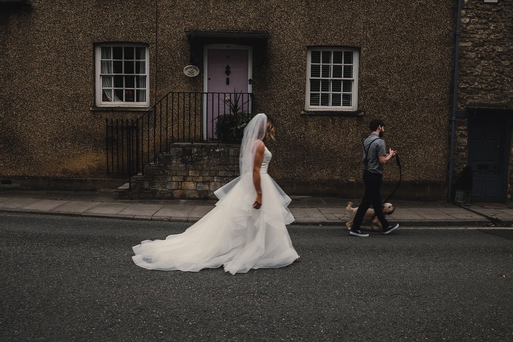 a bride and groom walking down their street