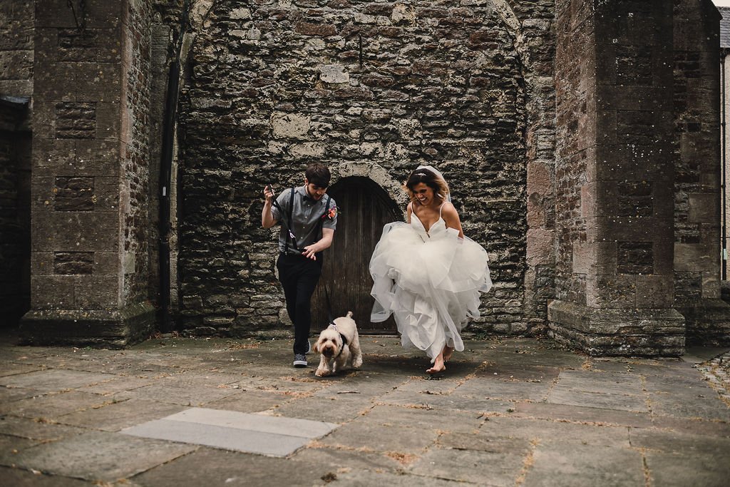 a bride and groom having fun with their dog 