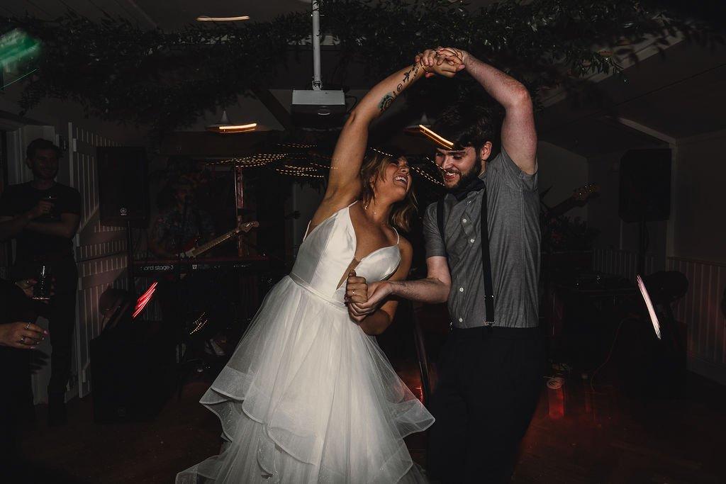 a bride and groom twisting on the dancefloor