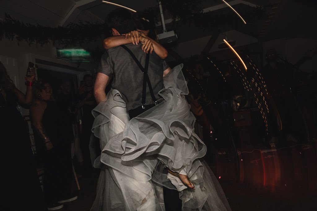 a groom carries his bride on the dancelfloor