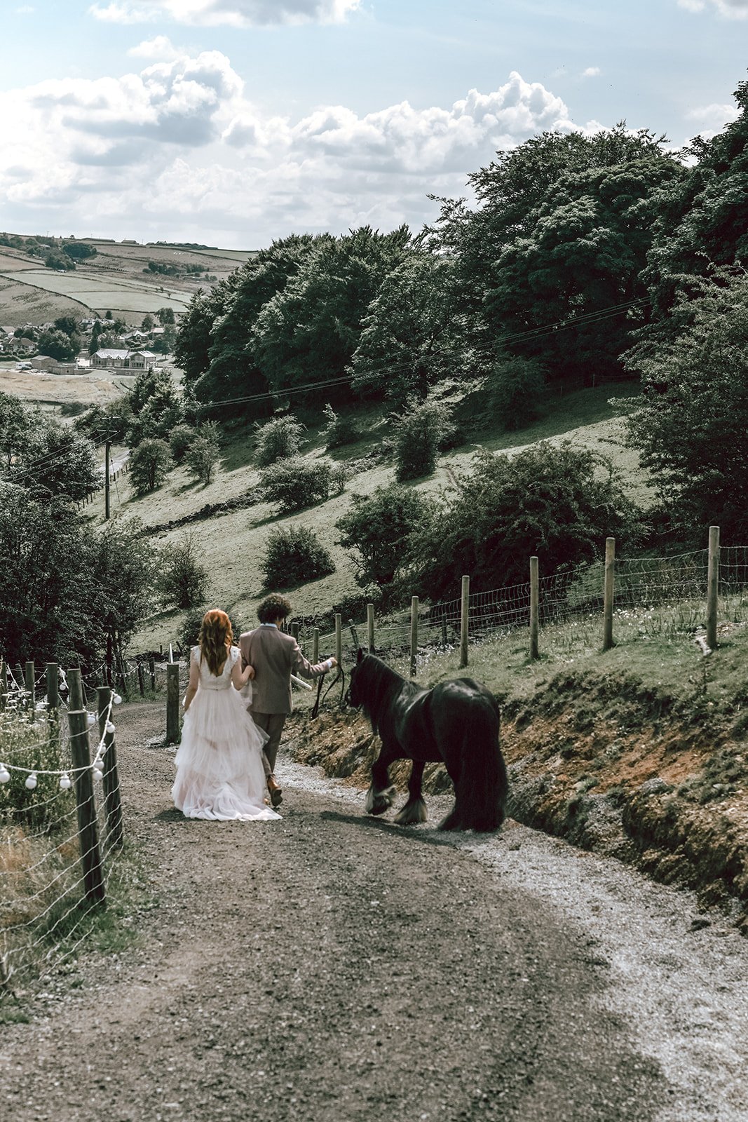 a bride and groom taking a pony for a walk