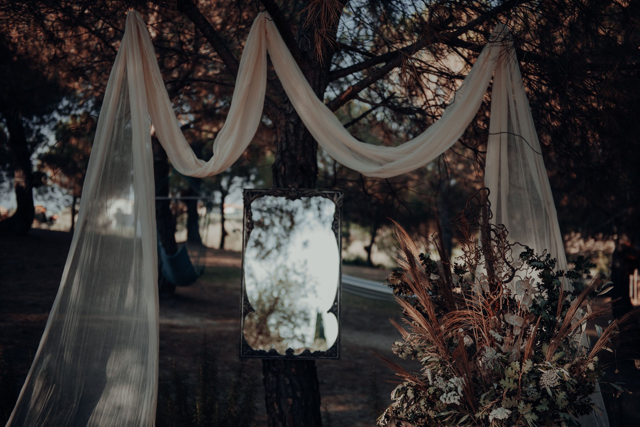  The setting: Olive trees with swooping material draped over it, there’s a mirror on an easel in the middle 