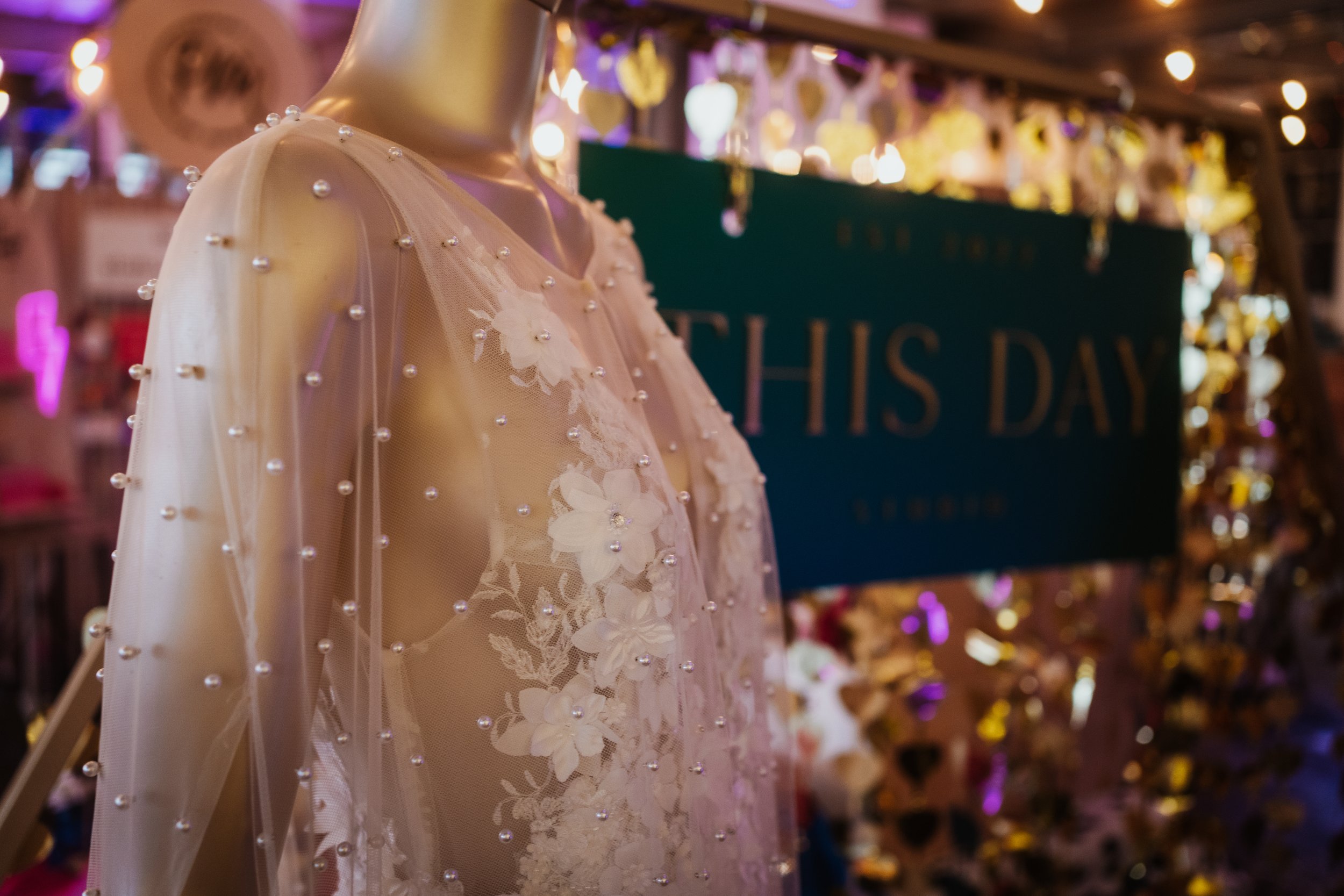  A close-up of a beautiful pearl bridal cape over a textured floral bridal dress at The Un-Wedding Show. 