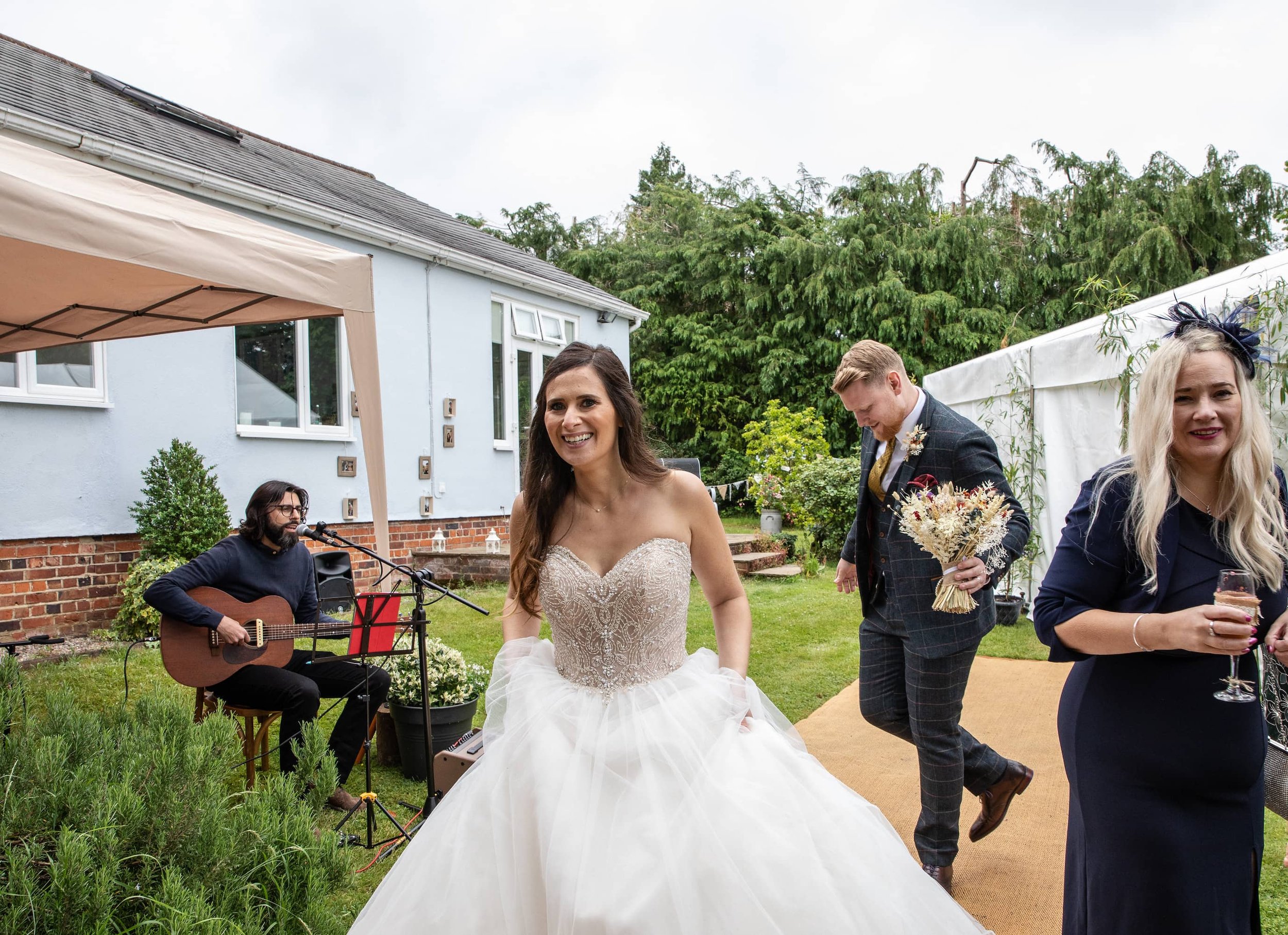  Acoustic musician can be seen playing the guitar and singing outside as the bride and groom walk past at their evening reception.  Photo by Lorna Newman Weddings 