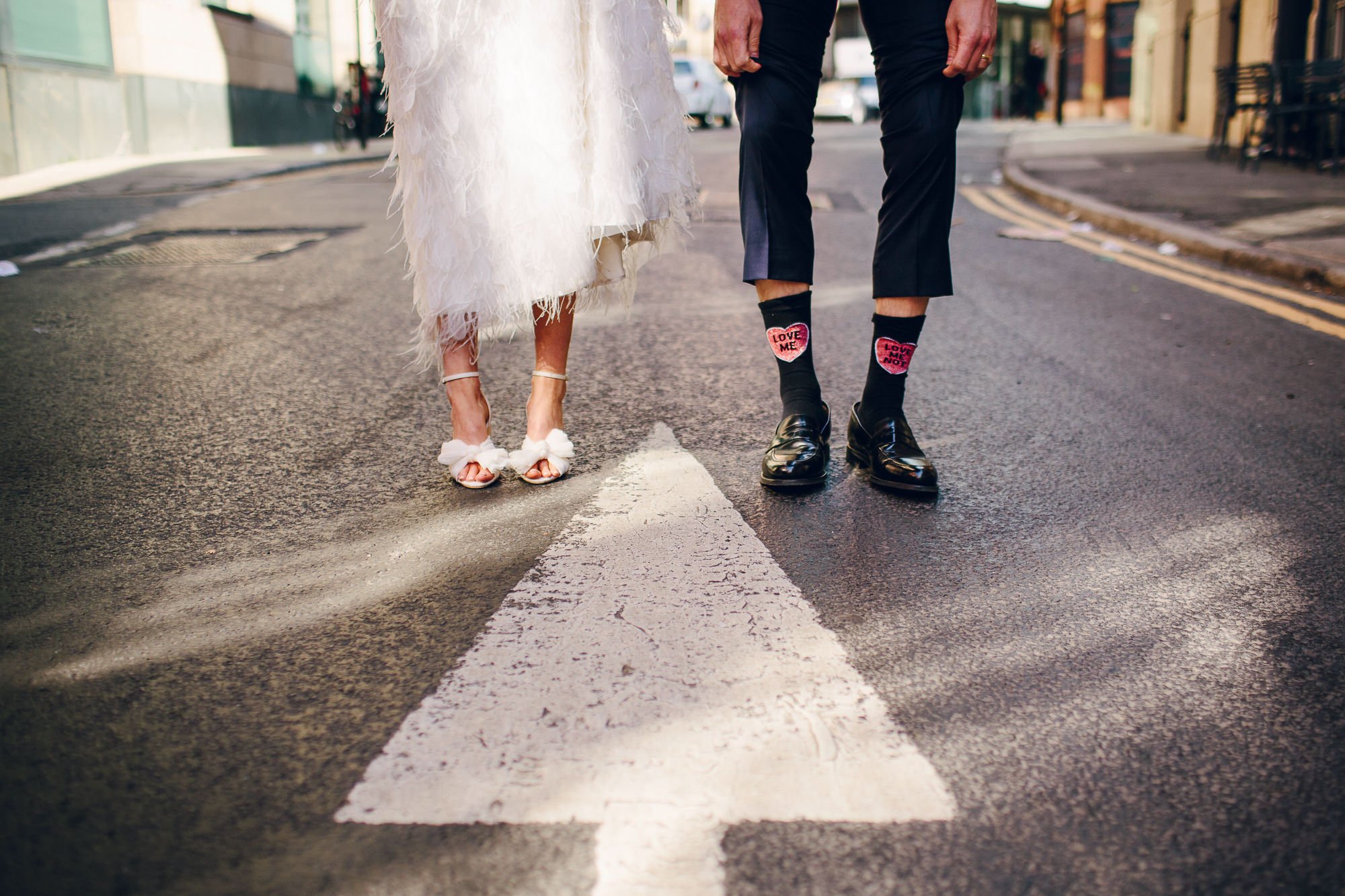  Stylish, modern image taken by the wedding photographer capturing all the small details on the newlyweds wedding day. The documentary style photographer has photographed the bride and groom from the knees down as they are stood at the top of a white