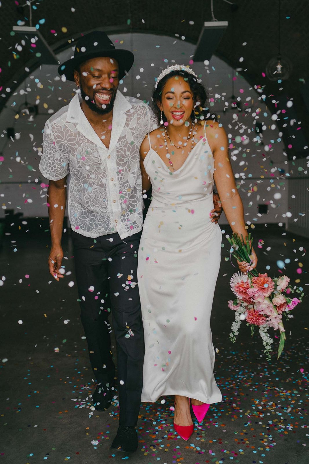  An image captured of newlyweds as their wedding guests cover them in confetti.  Photo by: Josephine Elvis 