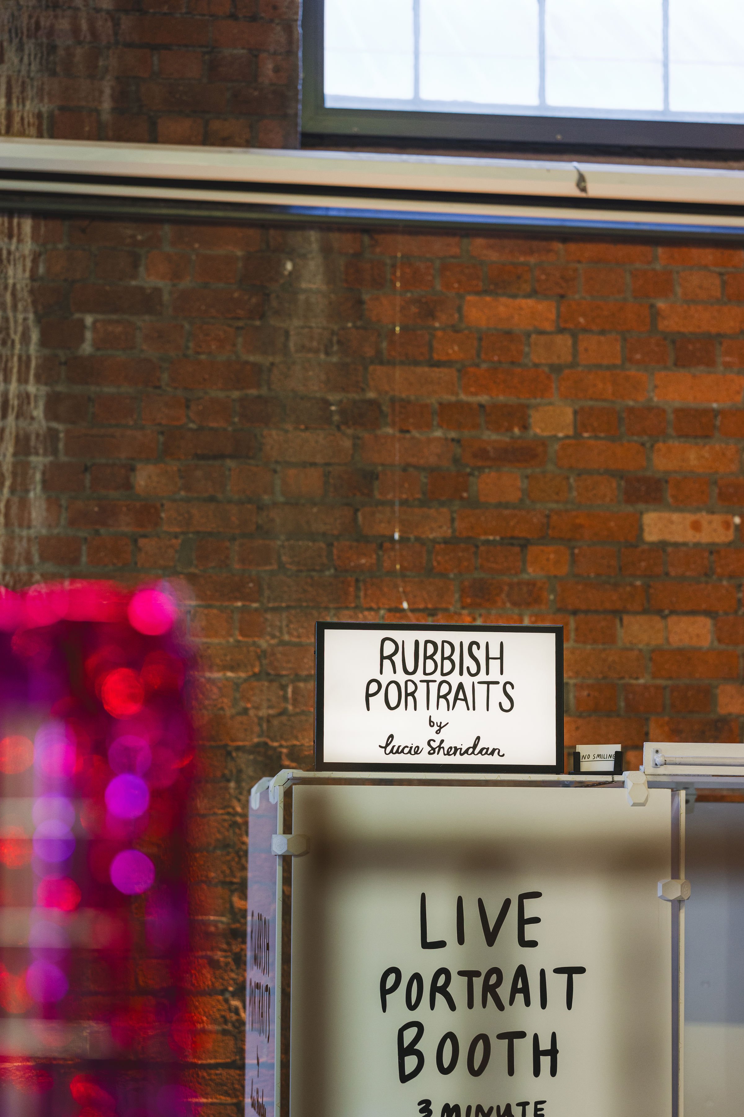  Bright lightbox of RUBBISH PORTRAITS live photobooth stands out against the exposed brick of Paintworks, the wedding venue where we held The Un-Wedding Show Bristol. 