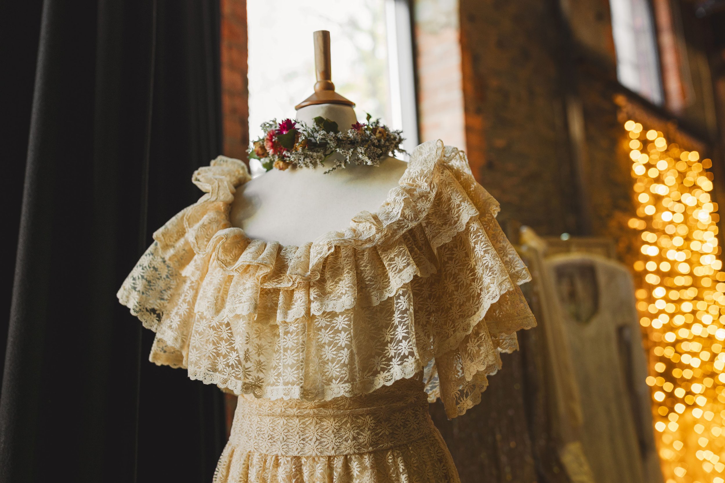  A close up of a beautiful vintage wedding dress displayed on a cream mannequin.  