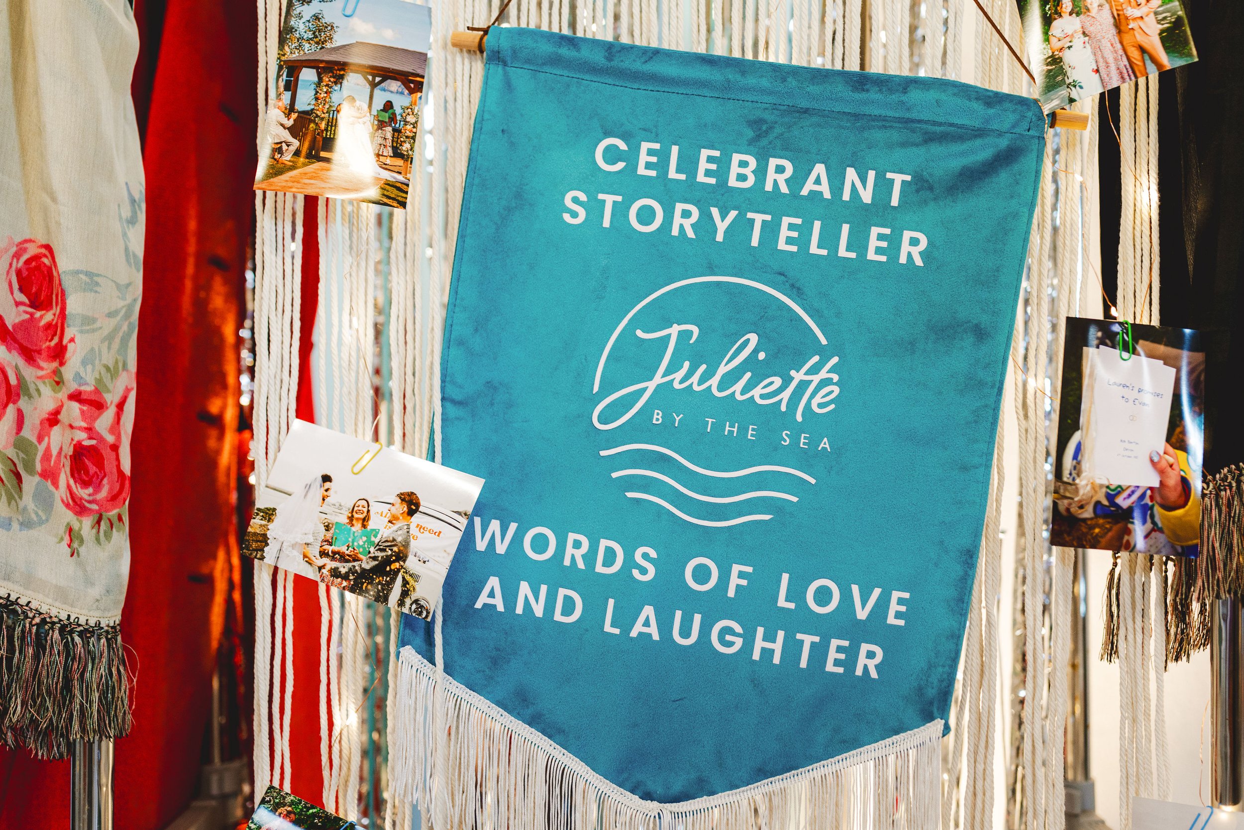  A bright blue banner with CELEBRANT STORYTELLER printed in white, hung amongst streamers. 