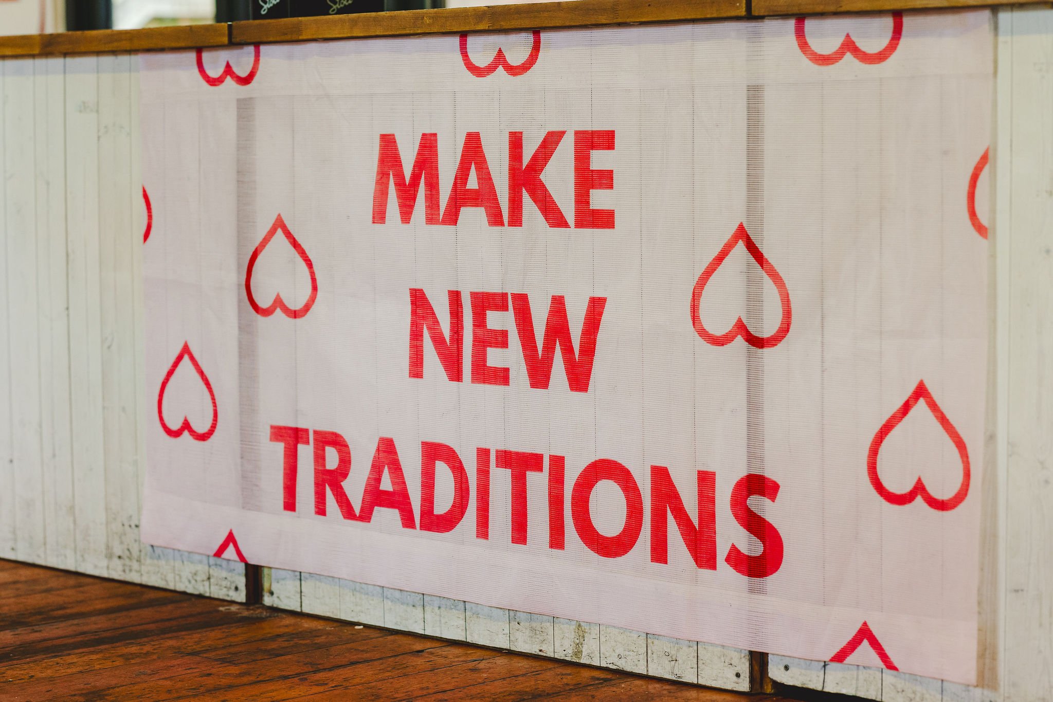  A MAKE NEW TRADITIONS banner is attached onto the front of the bar in Paintworks at The Un-Wedding Show Bristol. 