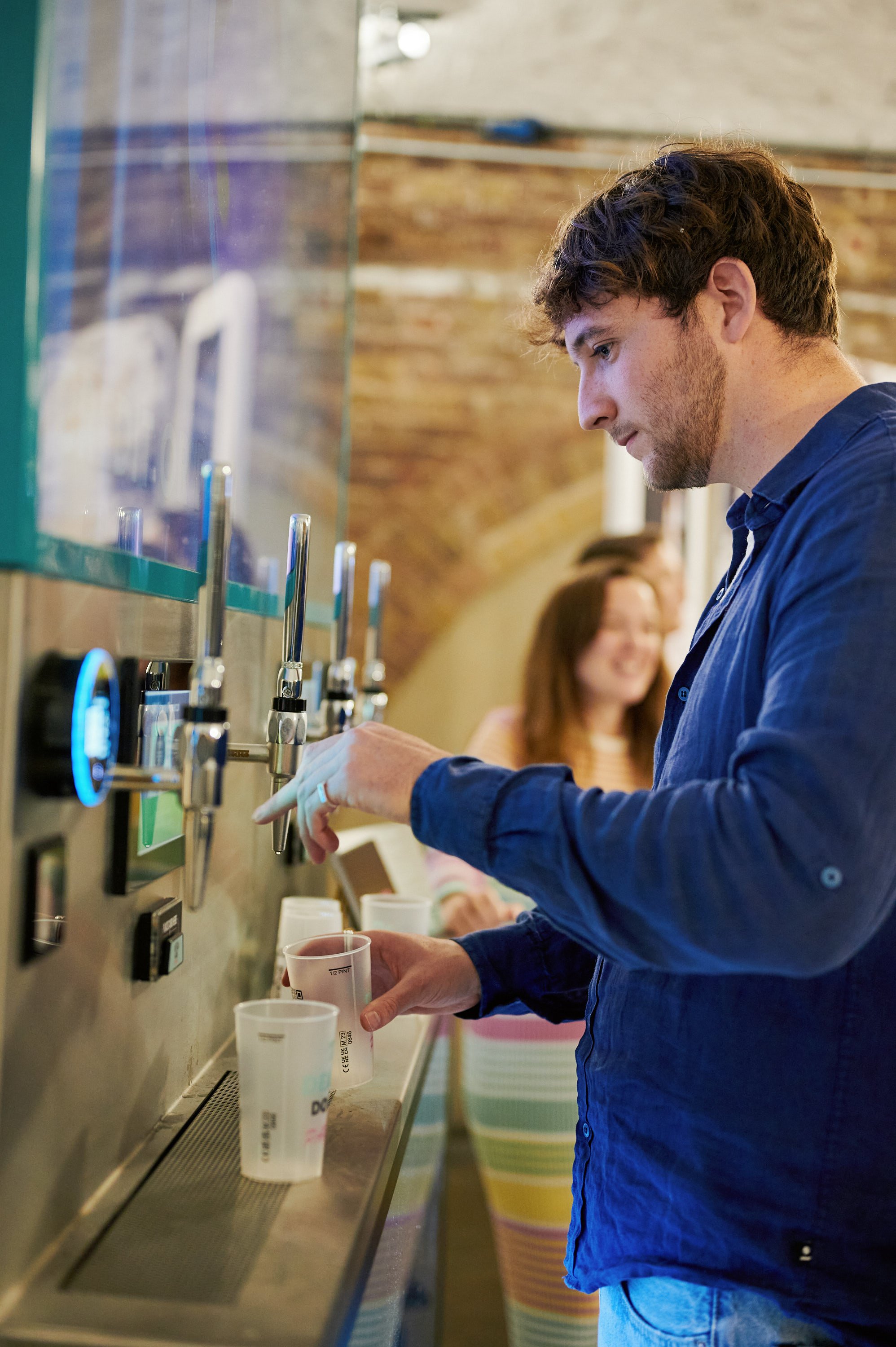  A man in a blue shirt using an interactive mobile bar at The Un-Wedding Show London. 