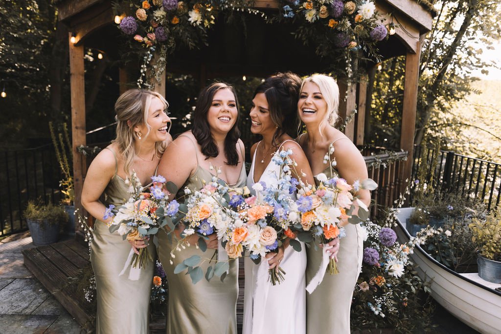  Modern wedding photographer has caught the authentic moment of the interaction between the bride and her three bridesmaids as they stand for photos. 