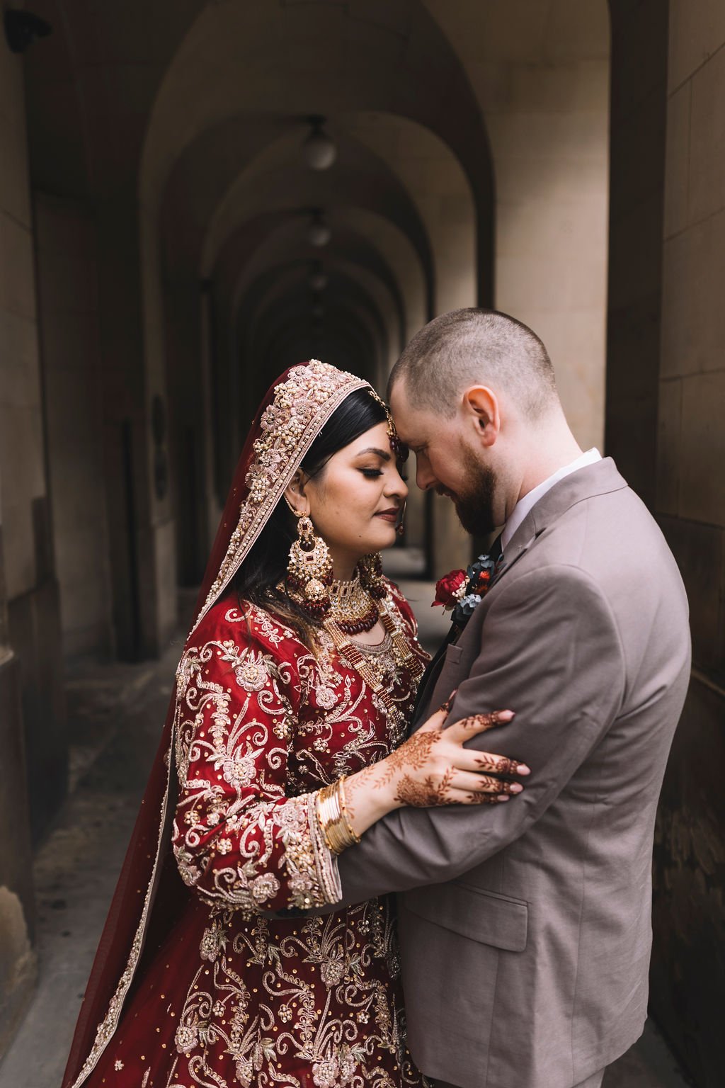  A beautiful, natural and authentic moment caught by the wedding photographer as the bride and groom hold each other close as they rest their foreheads together with their eyes shut. 