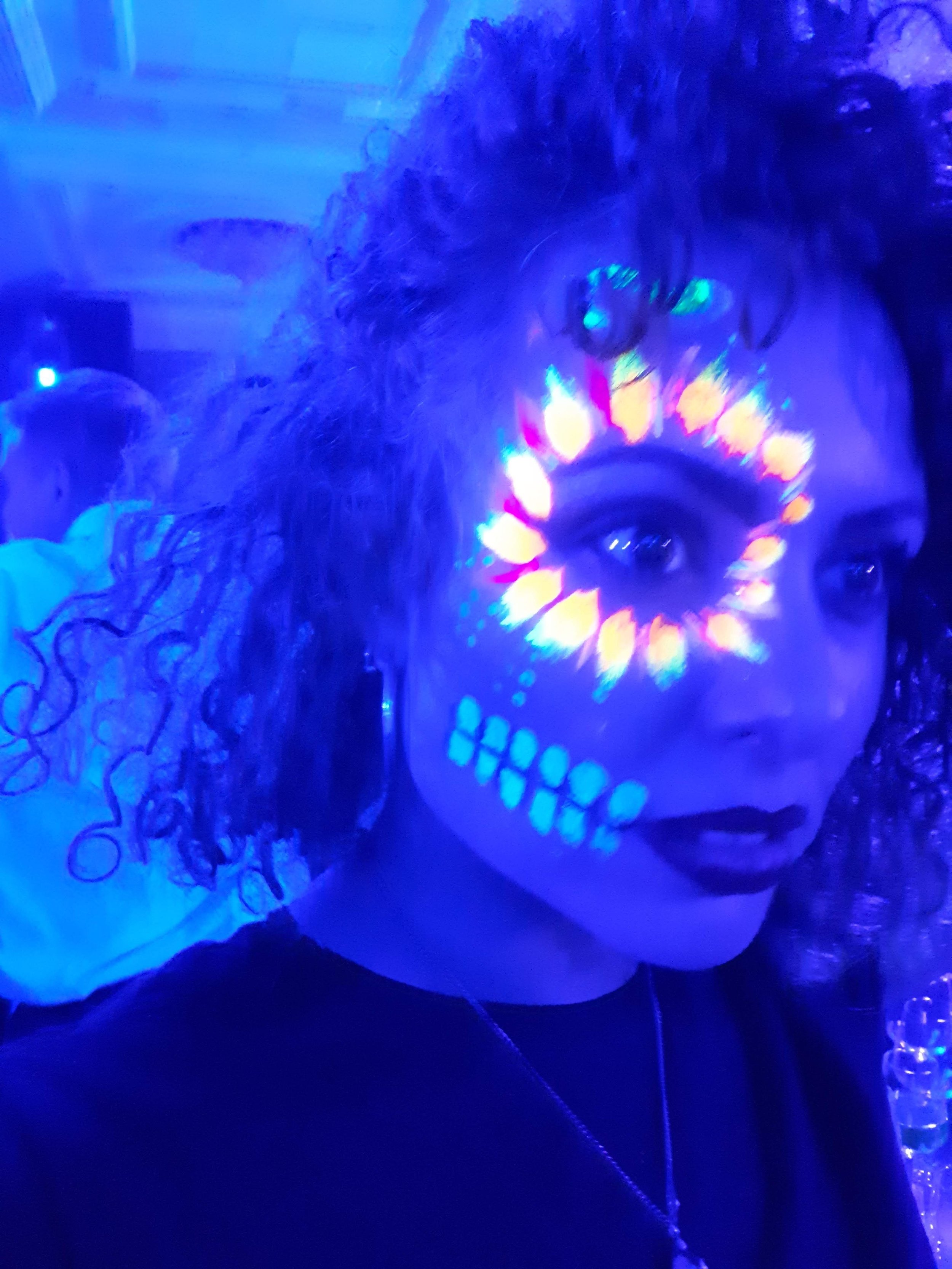  Neon UV paint has been applied to a wedding guest by fun roaming glitter &amp; UV artists at evening wedding reception.   Photo by: Fanny Burgos 