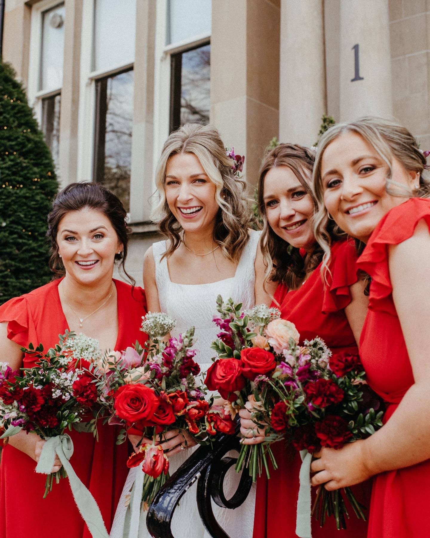  Stylish red and pink hand-tied floral bouquets, held by the bride and bridesmaids in the bridal party.  Photo by Lisa Devine Photography 