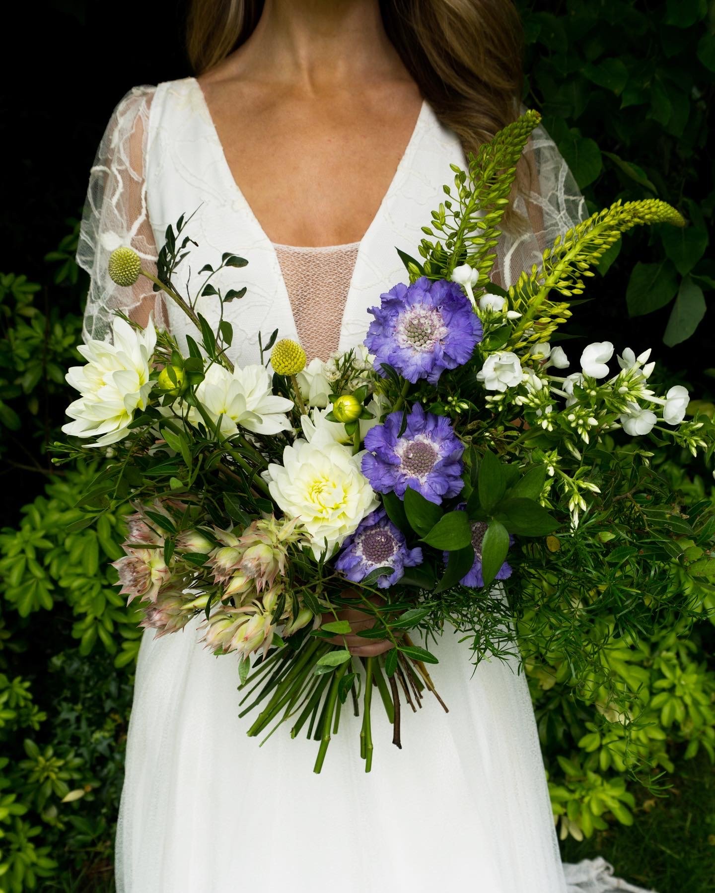  Stunning, bold bridal bouquet. The modern Glasgow based wedding florist has created a statement hand-tied floral arrangement using cream and neutral blooms with pops of blue and green foliage. 