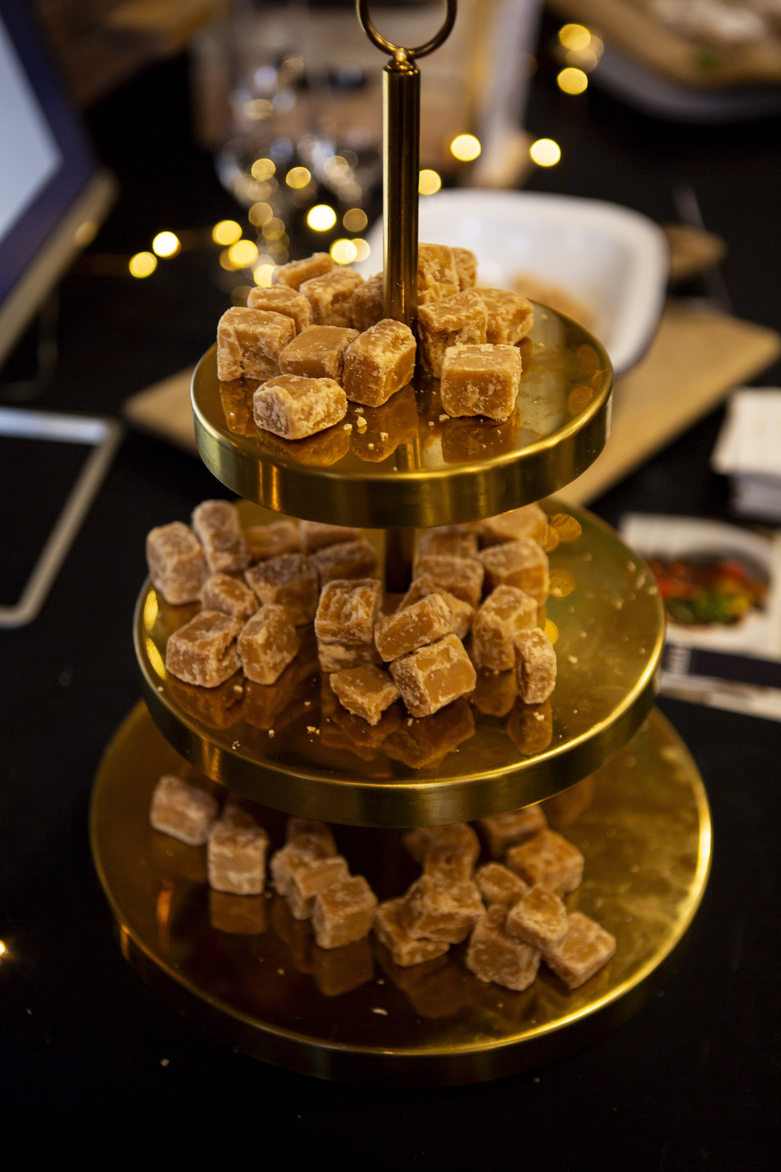  Up close image of gold, 3-tiered cake stand with bite-sized pieces of fudge for The Un-Wedding Show Scotland attendees to enjoy! 