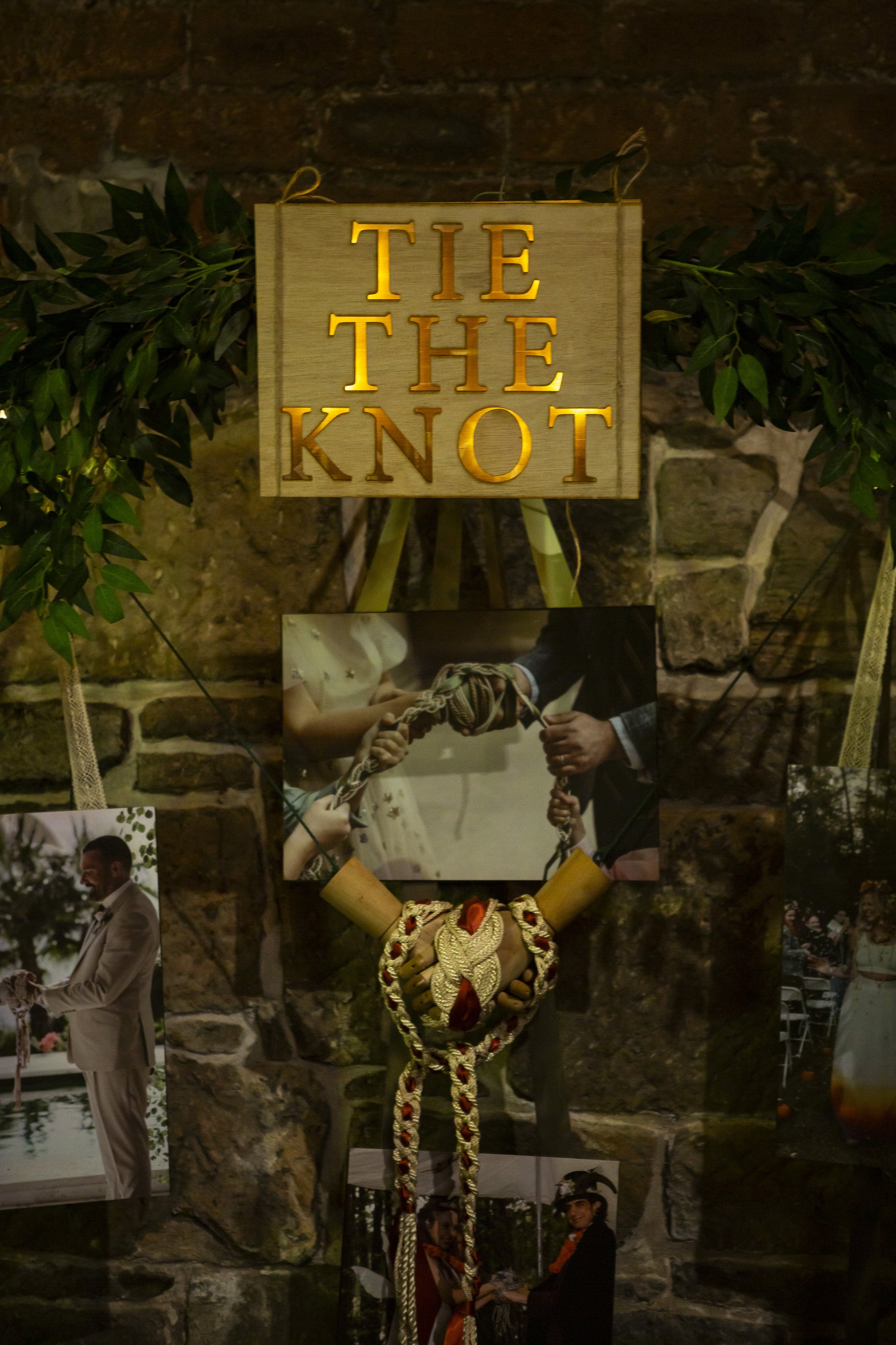  Beautiful celebrant stand with hand tying images displayed alongside a large gold sign which says TIE THE KNOT at The Un-Wedding Show Scotland. 