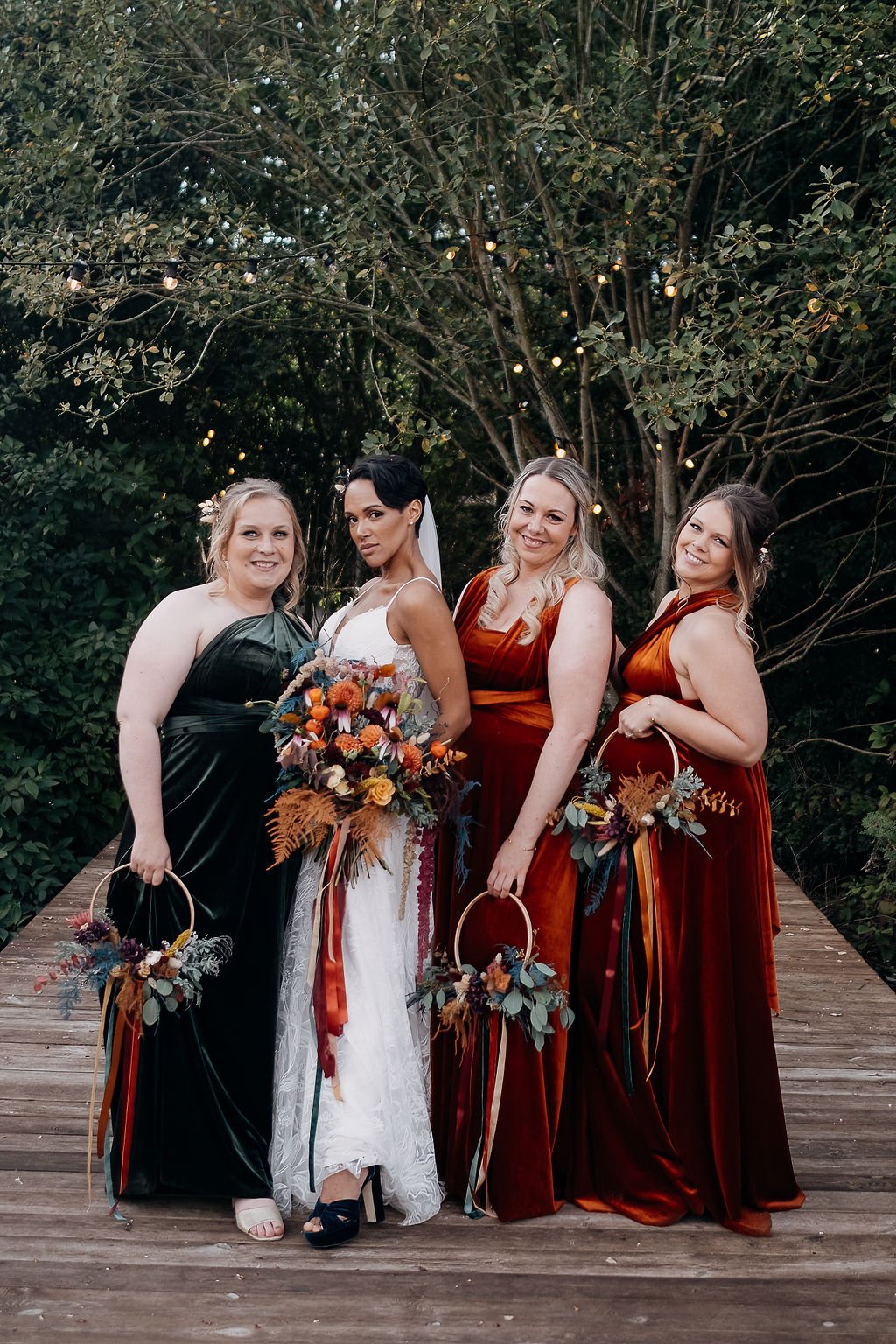  Bride is stood holding her autumnal coloured, hand-tied wedding bouquet. The quirky, modern florists have used lots of different florals, textures and foliage to create the shape and interest. The cool florists have reflected the bridal bouquet in t