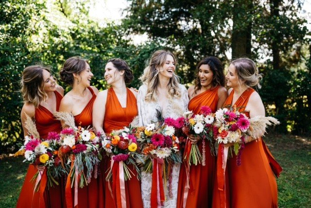  Bridesmaids either side of bride holding modern, colour clashing hand-tied wedding party bouquets, using florals with a mixture of colours and textures.  Photo by P Grace Photography 