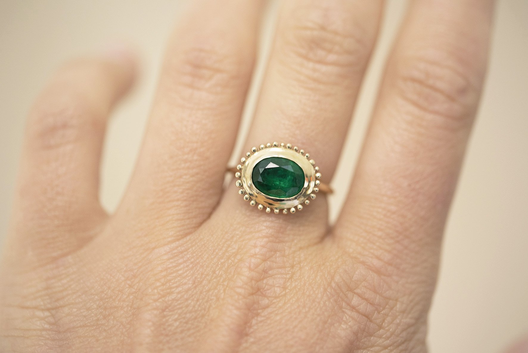  A slim gold band with a large oval emerald with a gold surround is the perfect, modern engagement ring. 