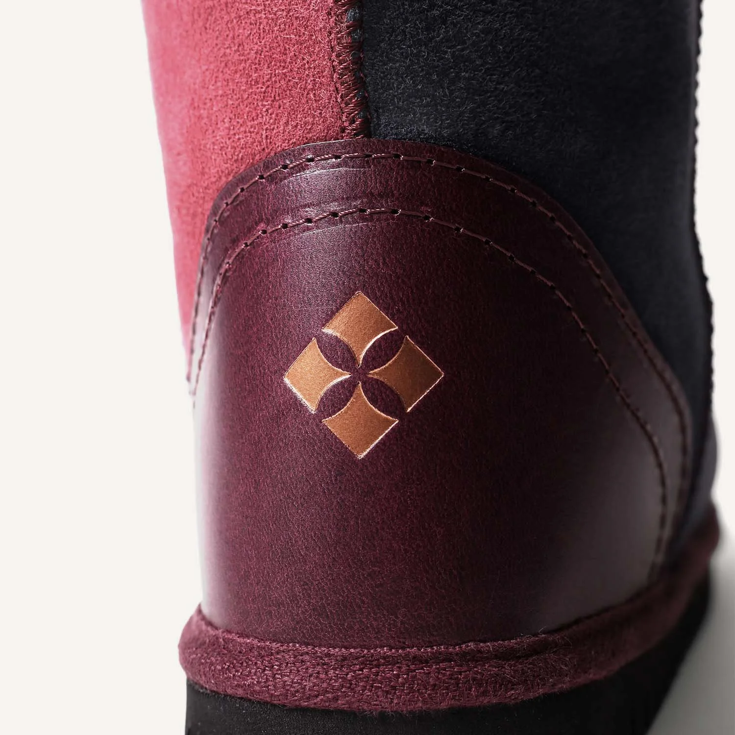 Close up of purple leather heel with copper metallic logo.